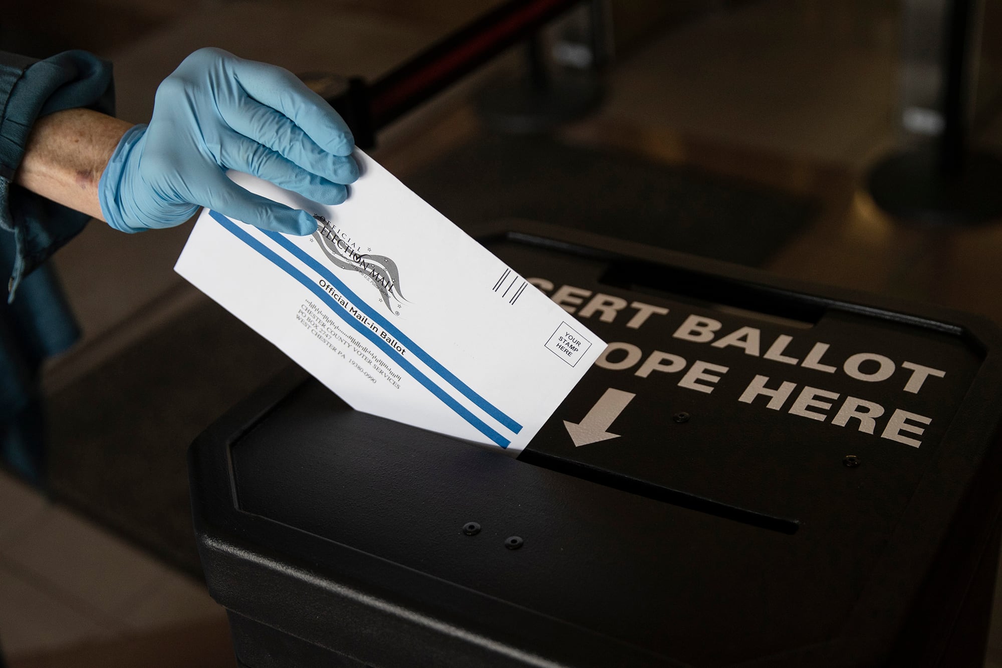 In this May 28, 2020, file photo a voter casts her mail-in ballot at in a drop box in West Chester, Pa., prior to the primary election. Just over four months before Election Day.