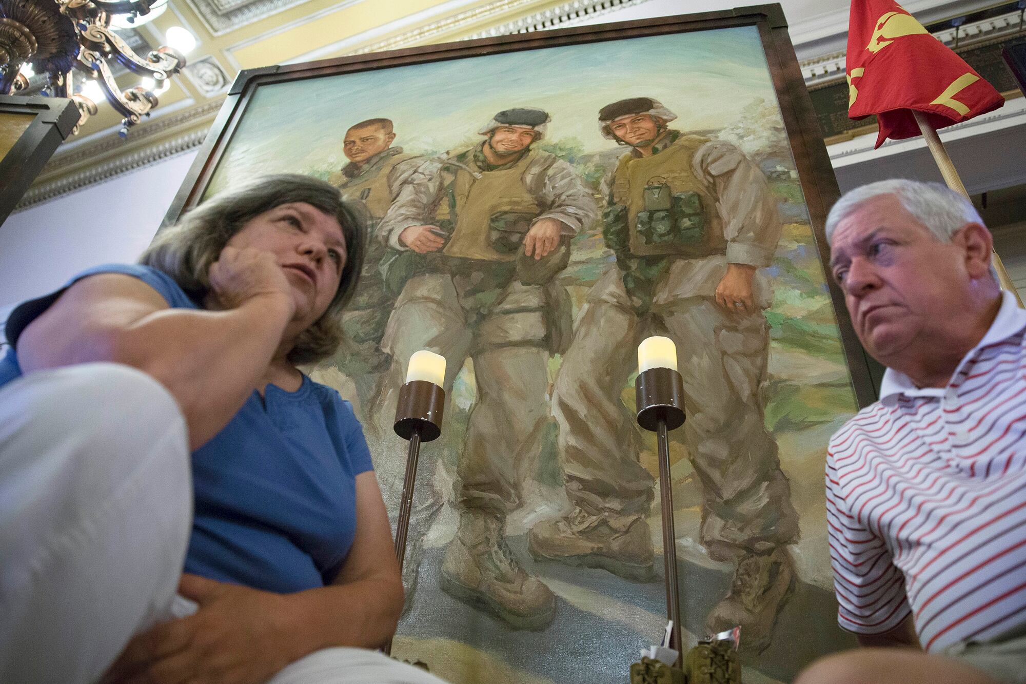 In this file photo from July 28, 2015, Pat Murray, left, and Ken Kreuter sit beneath a portrait of their son Marine Sgt. David Kreuter, top right, at the traveling Eyes of Freedom Lima Company Memorial, then displayed at the Cincinnati Masonic Center.