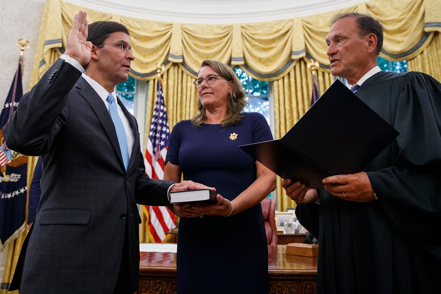 Mark Esper, left, is sworn in as the Secretary of Defense by Supreme Court Justice Samuel Alito, right, as his wife Leah Esper holds the Bible, during a ceremony with President Donald Trump in the Oval Office at the White House in Washington, Tuesday, July 23, 2019.