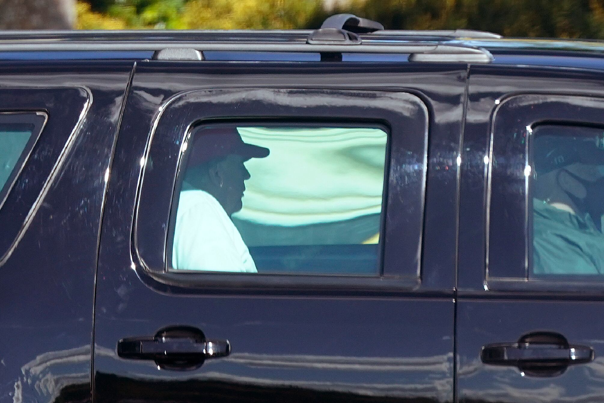 President Donald Trump rides in a motorcade vehicle as he departs Trump International Golf Club, Sunday, Dec. 27, 2020, in West Palm Beach, Fla.