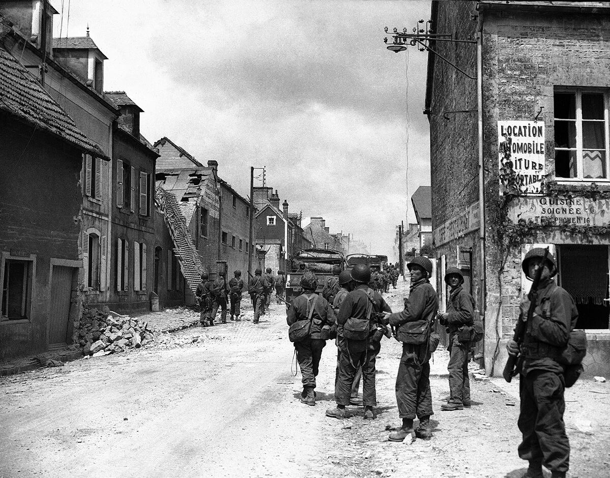 American paratroops patrol in Sainte-Mere-Eglise, France, during World War II.