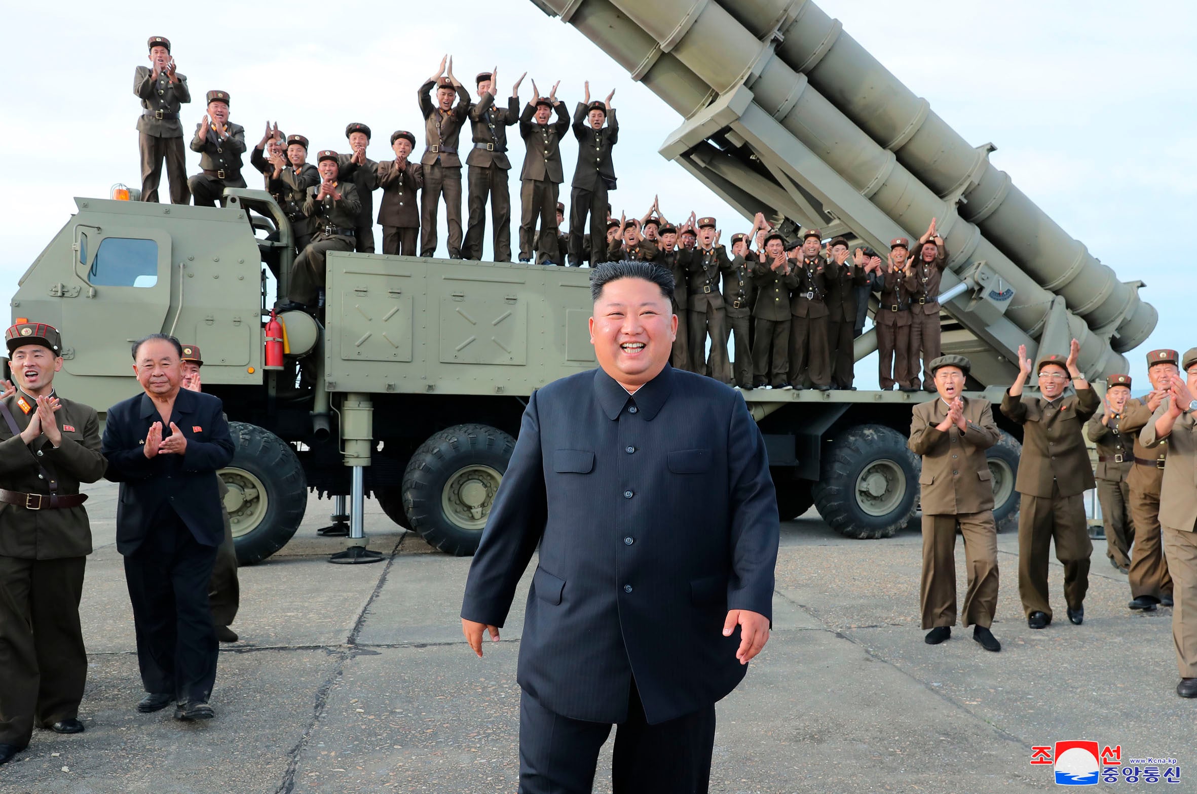 This Aug. 24, 2019, photo provided Aug. 25, shows North Korean leader Kim Jong Un, center, smiling after the test firing of an unspecified missile at an undisclosed location in North Korea.