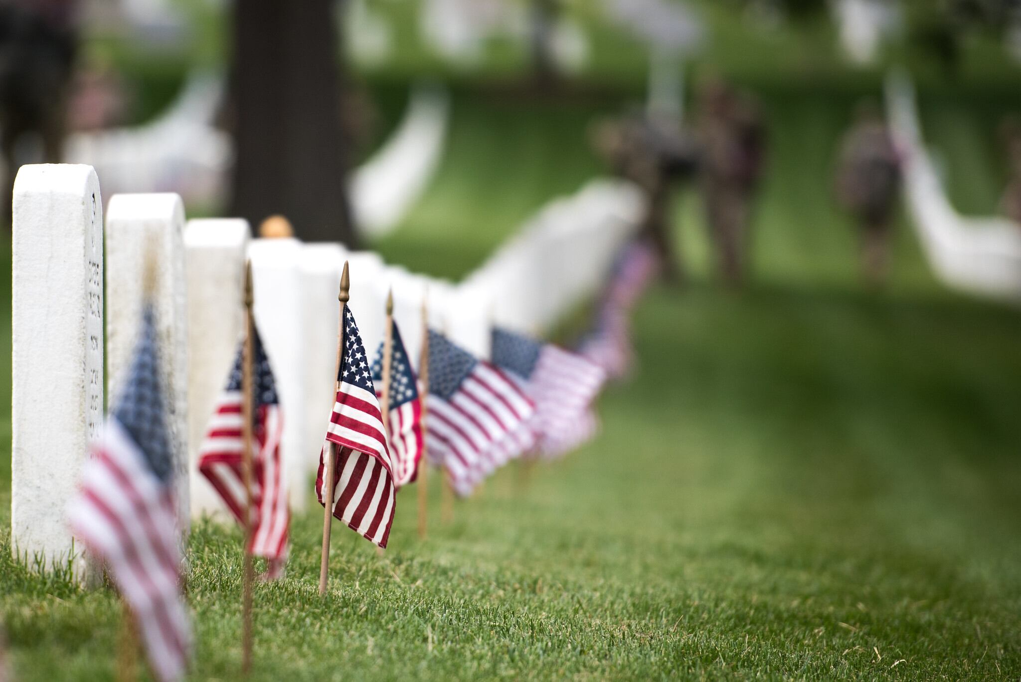 Soldiers with the 3d U.S. Infantry Regiment (The Old Guard) place flags at headstones in Arlington National Cemetery, Arlington, Va., during flags-In, May 23, 2019.