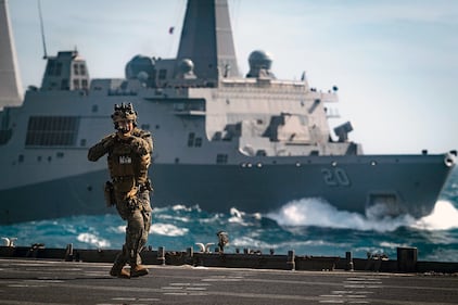 A Force Reconnaissance Marine clears the flight deck of the amphibious dock landing ship USS Ashland (LSD 48) on July 7, 2019, during a visit, board, search and seizure training exercise with the amphibious transport dock ship USS Green Bay (LPD 20) in the Coral Sea.