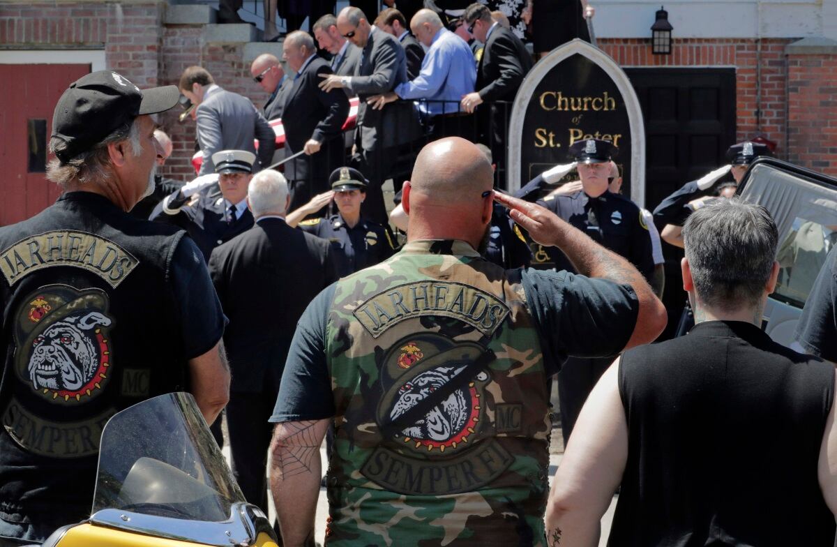 Members of the Jarheads Motorcycle Club and a police honor guard salute as the casket of Michael Ferazzi is loaded into a hearse outside St. Peter's Catholic Church in Plymouth, Mass., Friday, June 28, 2019.