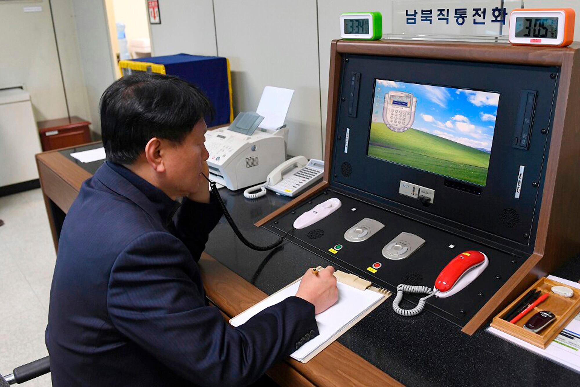 In this Jan. 3, 2018, file photo, a South Korean government official communicates with a North Korean officer during a phone call on the dedicated communications hotline at the border village of Panmunjom in Paju, South Korea.