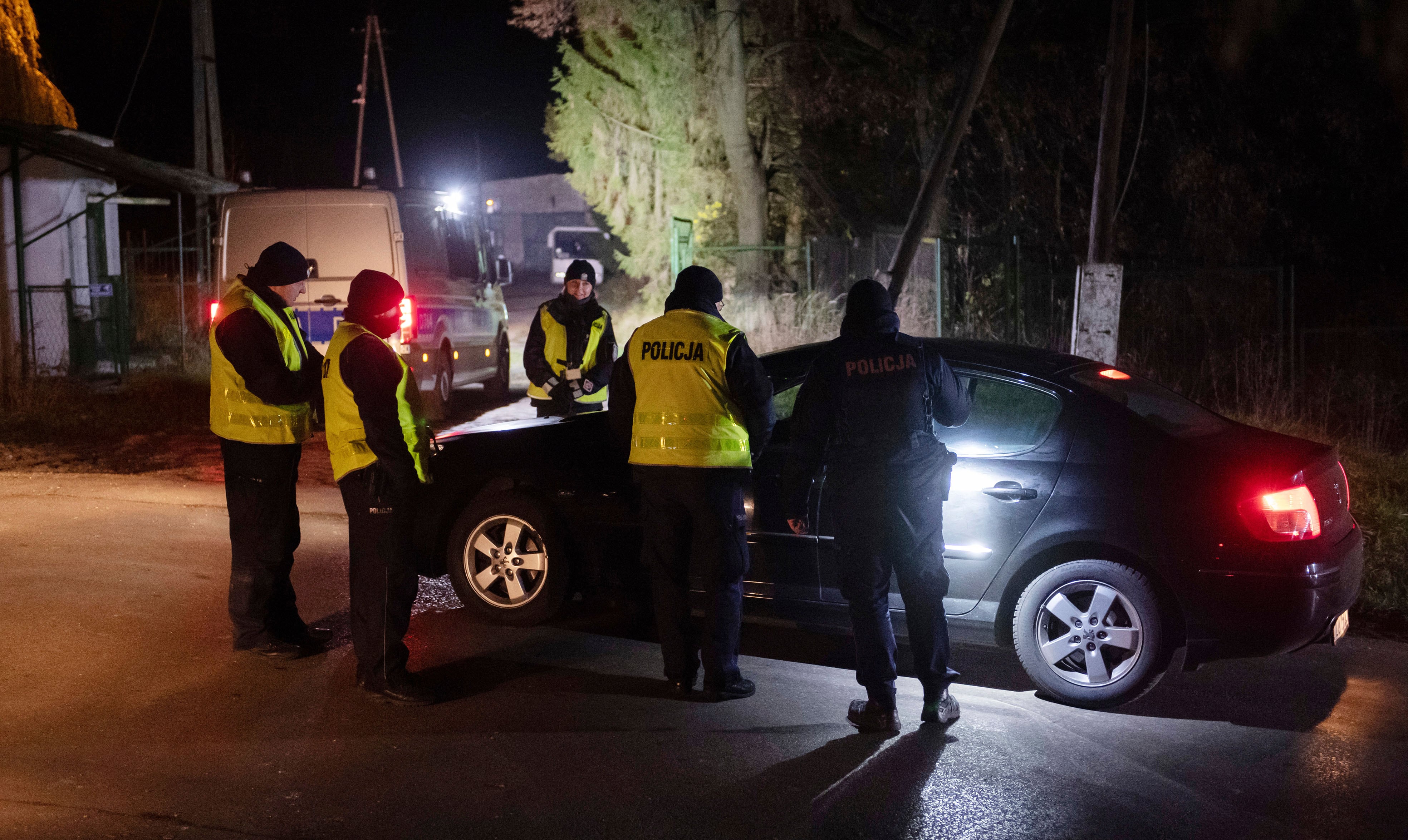 Police officers gather outside a grain depot in Przewodow, eastern Poland, on Tuesday Nov. 15, 2022 where the Polish Foreign Ministry said that a Russian-made missile fell and killed two people.