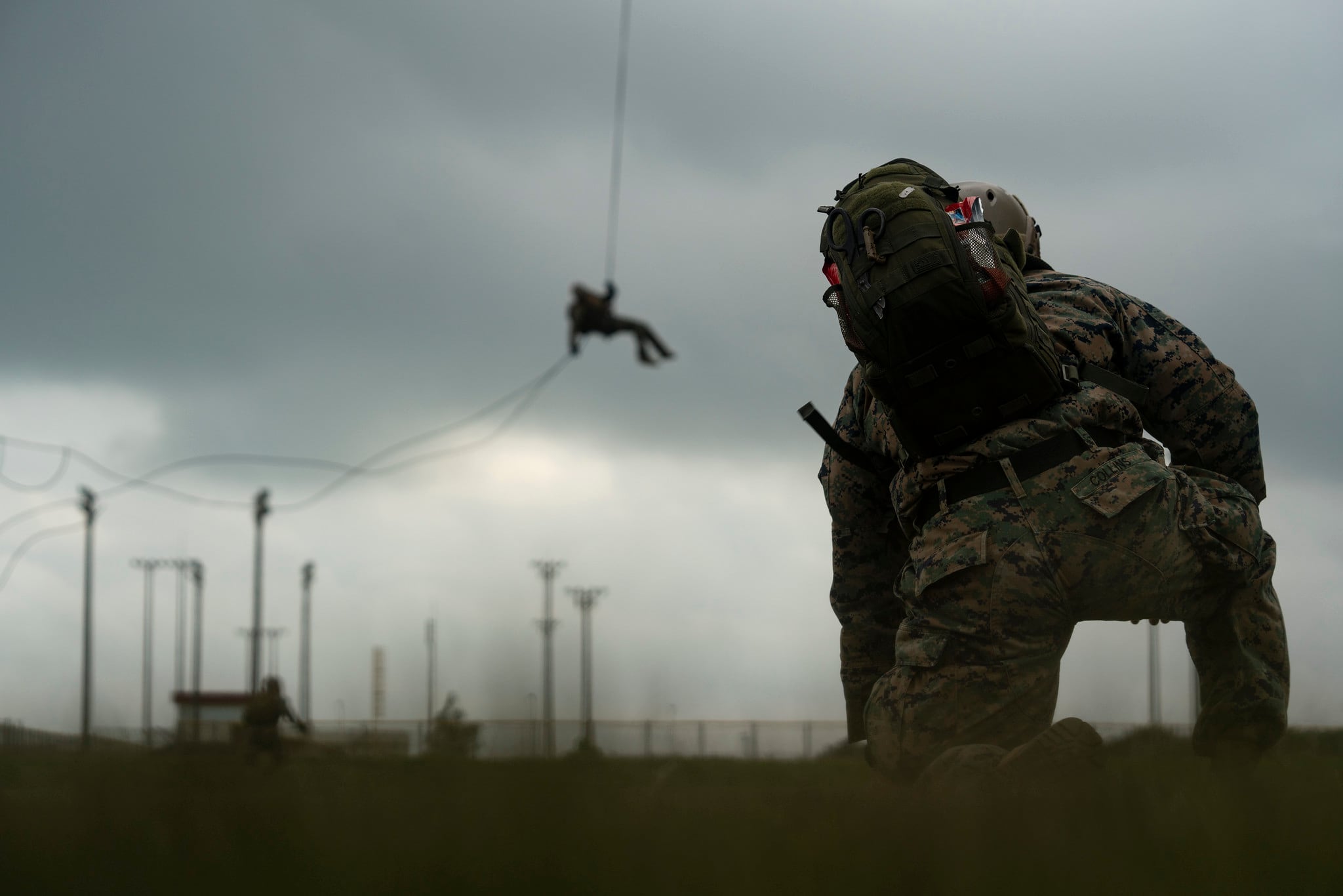 A U.S. Navy corpsman with Expeditionary Operations Training Group, III Marine Expeditionary Force Information Group, supervises students performing helicopter rope suspension technique training at the parade deck on Camp Hansen, Okinawa, Japan,  Aug. 14, 2019.