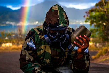 A Marine drinks water while in full mission oriented protective posture (MOPP) gear during a unit-held uphill run on Marine Corps Base Hawaii, June 11, 2020.