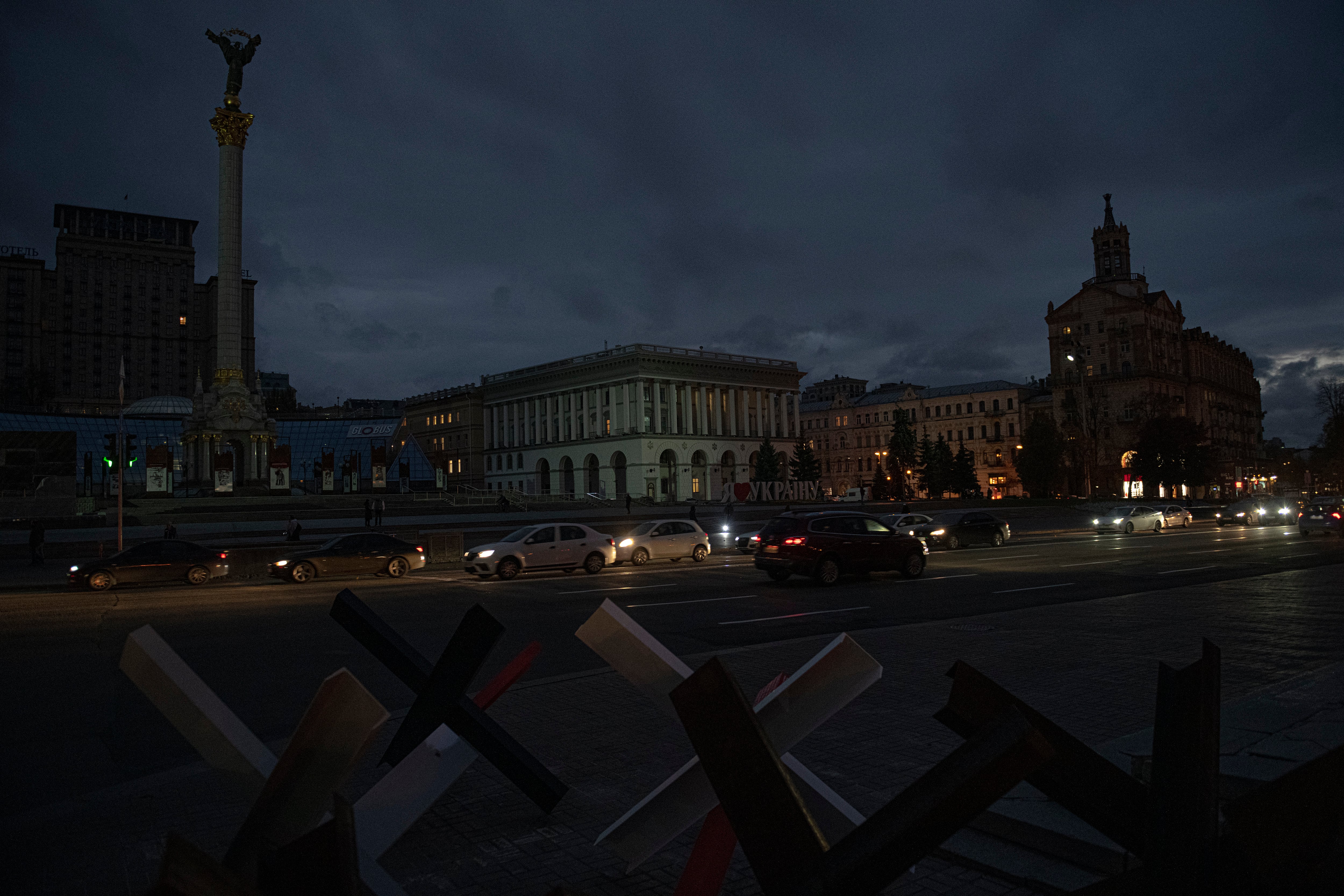 Cars pass in Independence Square at twilight in Kyiv, Ukraine, Monday, Oct. 31, 2022.