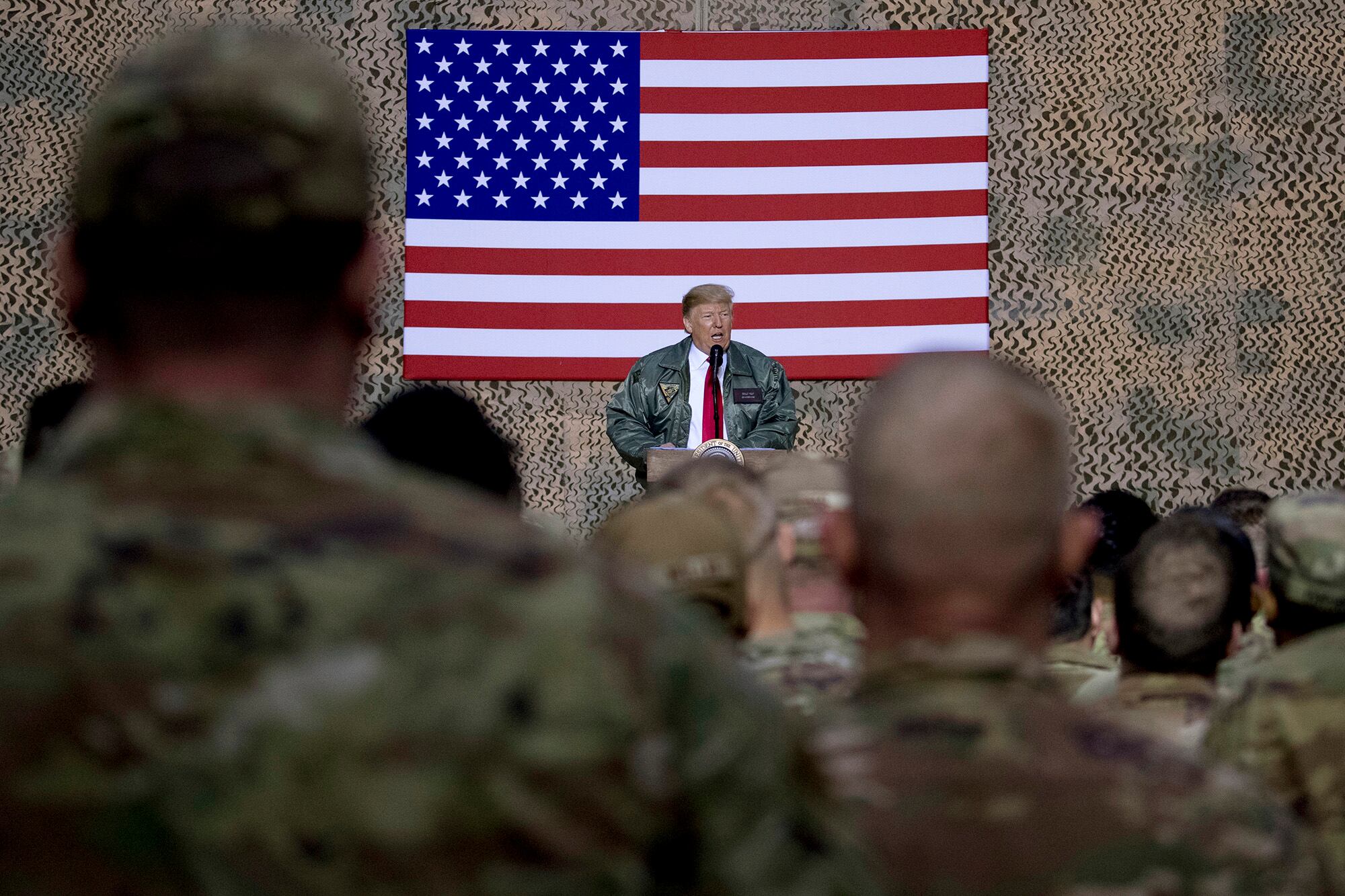 In this Dec. 26, 2018, file photo, President Donald Trump speaks to members of the military at a hangar rally at Al Asad Air Base, Iraq.