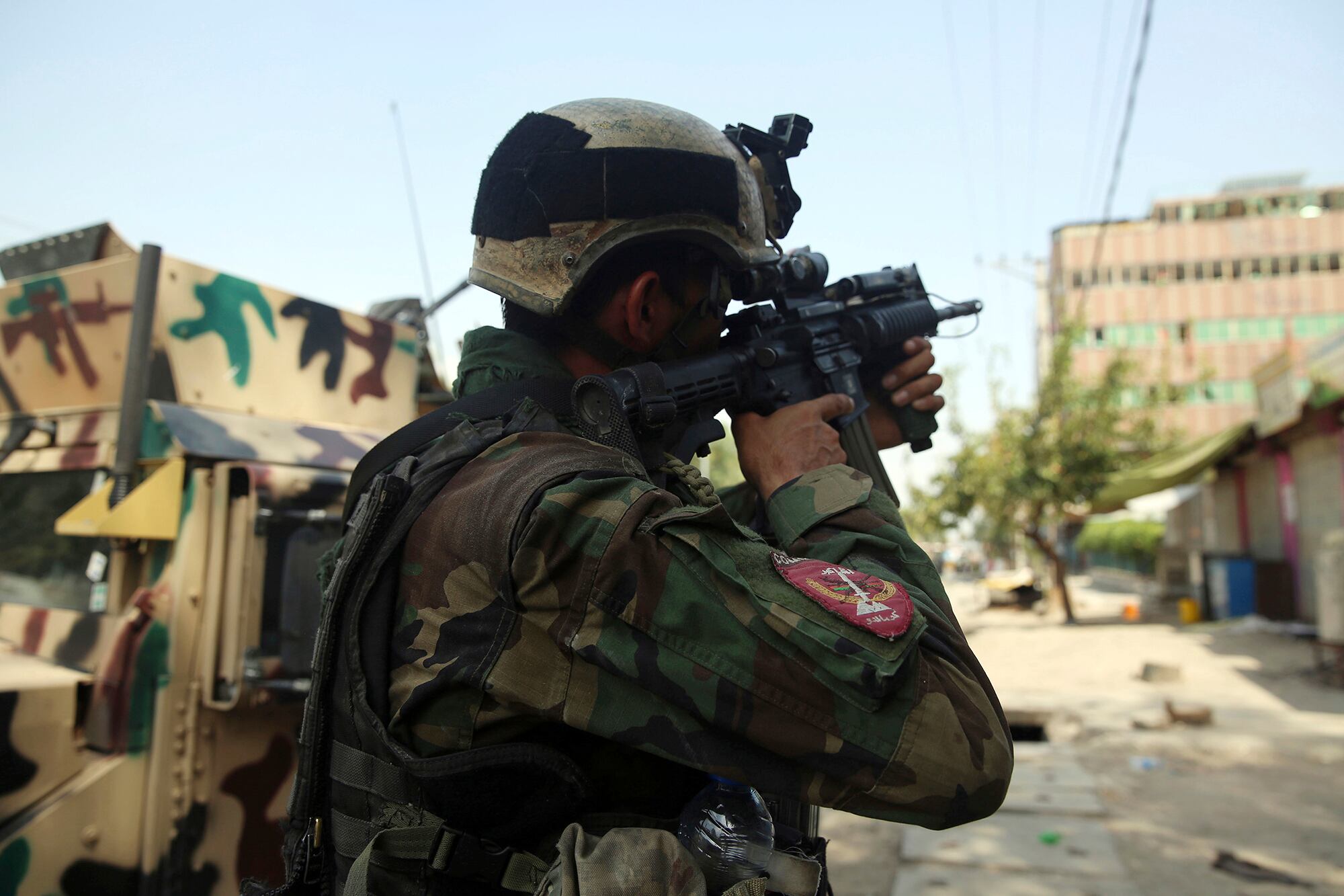 An Afghan security person takes position in front of a prison after an attack in the city of Jalalabad, east of Kabul, Afghanistan, Monday, Aug. 3, 2020