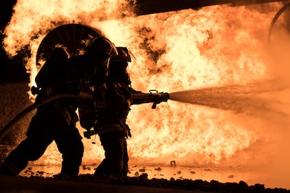 Brent Hardsaw, 22nd Civil Engineer Squadron fire inspector, and Airman 1st Class Trace James, 22nd CES fire protection apprentice, extinguish flames during an annual night aircraft burn, Sept. 18, 2020, at McConnell Air Force Base, Kan.