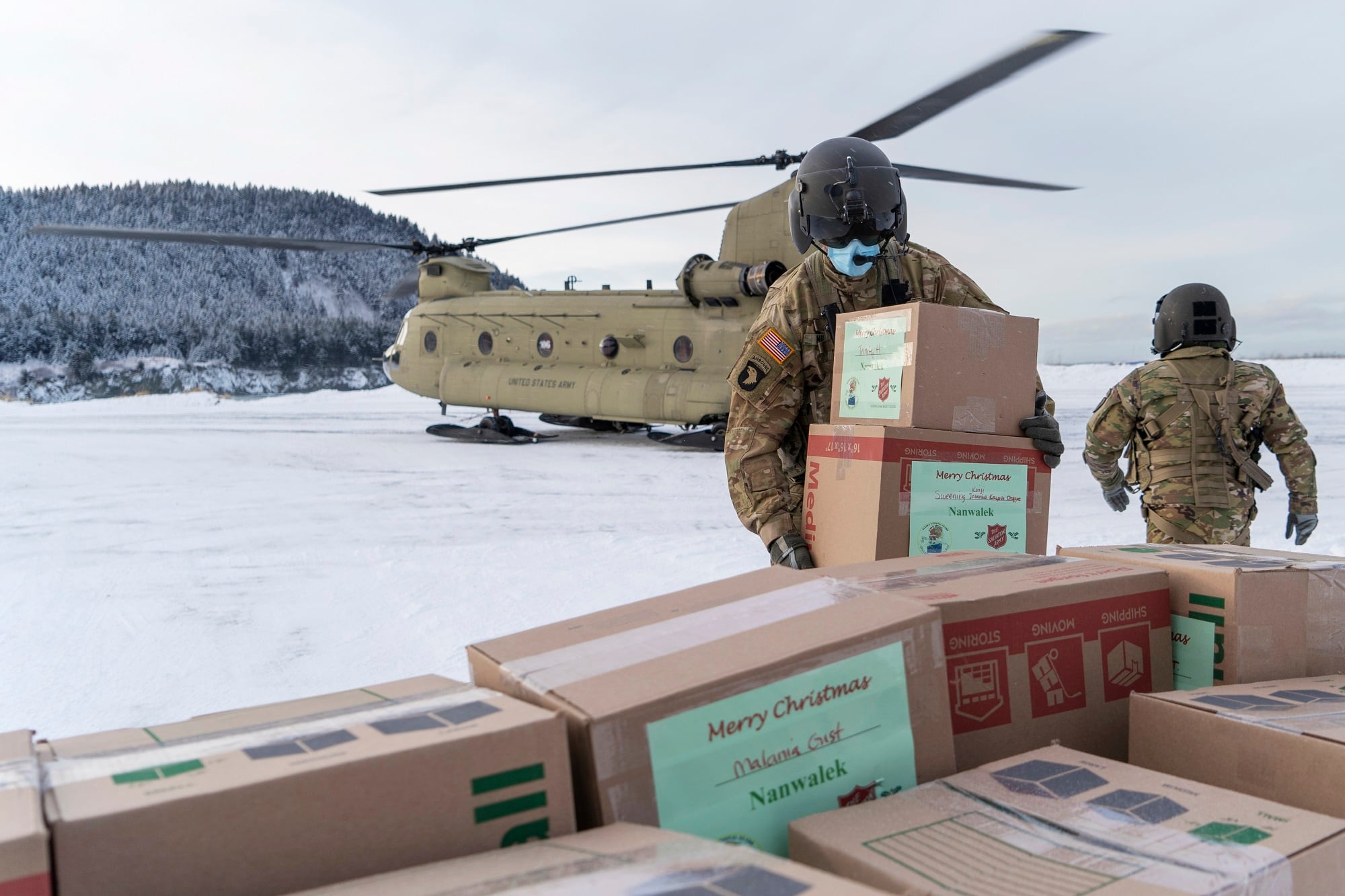 Soldiers unload gifts from a CH-47 Chinook helicopter in Nanwalek, Alaska, during Operation Santa Claus, on Dec. 11, 2020.