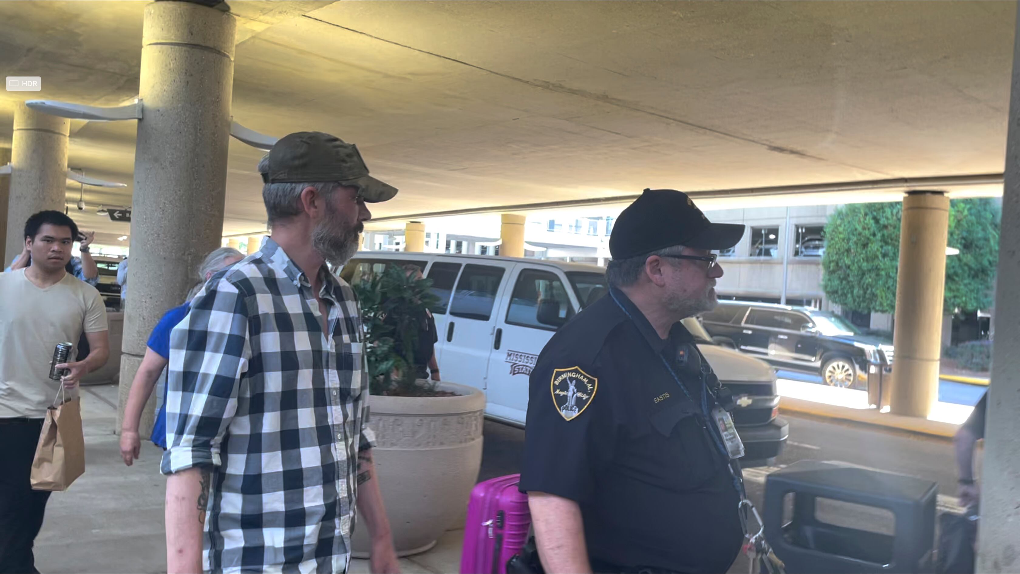 Andy Huynh, far left, and Alex Drueke, right, are seen leaving Birmingham-Shuttlesworth International Airport in Birmingham, Ala., Saturday, Sept. 24, 2022.