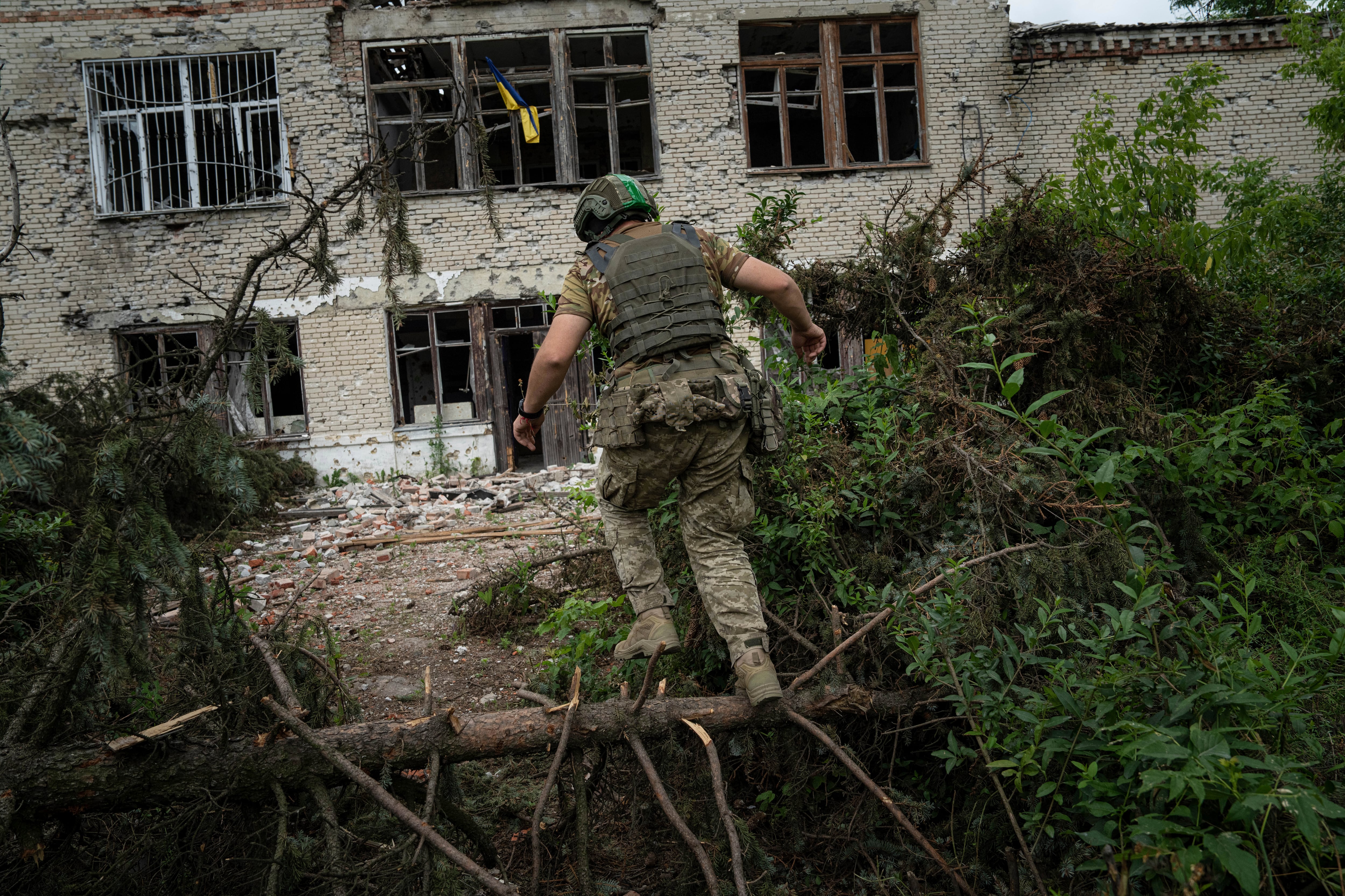 A Ukrainian serviceman of the 68th Oleksa Dovbush hunting brigade runs to his position in the recently retaken village of Blahodatne, Ukraine, Saturday, June 17, 2023.