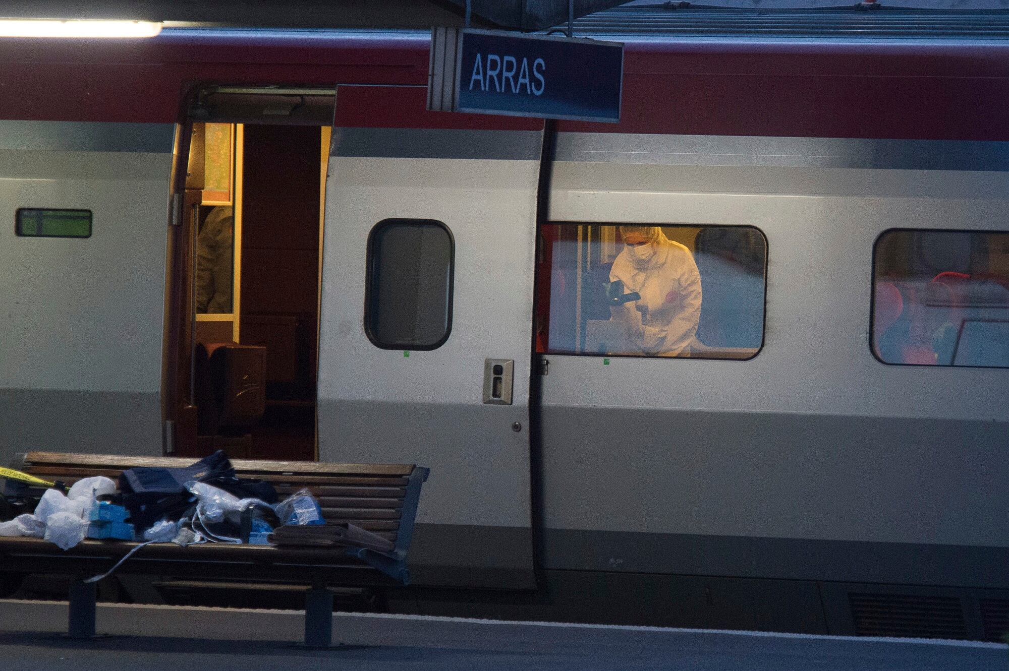 In this Aug. 21, 2015, file photo, a police officer videos the crime scene inside a Thalys train at Arras train station, northern France, after a gunman opened fire with an automatic weapon.