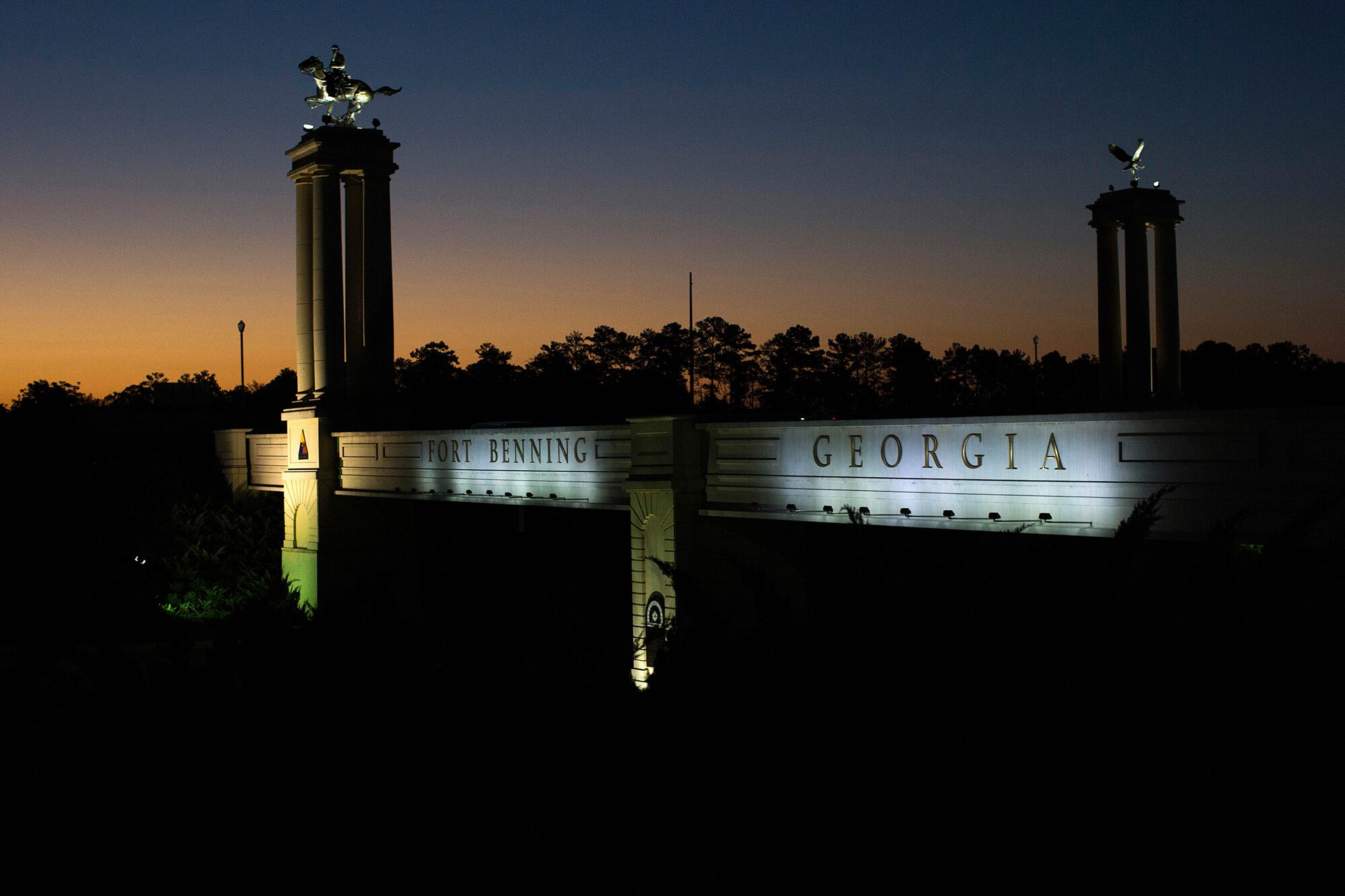 In this Oct. 16, 2015, file photo a bridge marks the entrance to the U.S. Army's Fort Benning as the sun rises in Columbus, Ga.