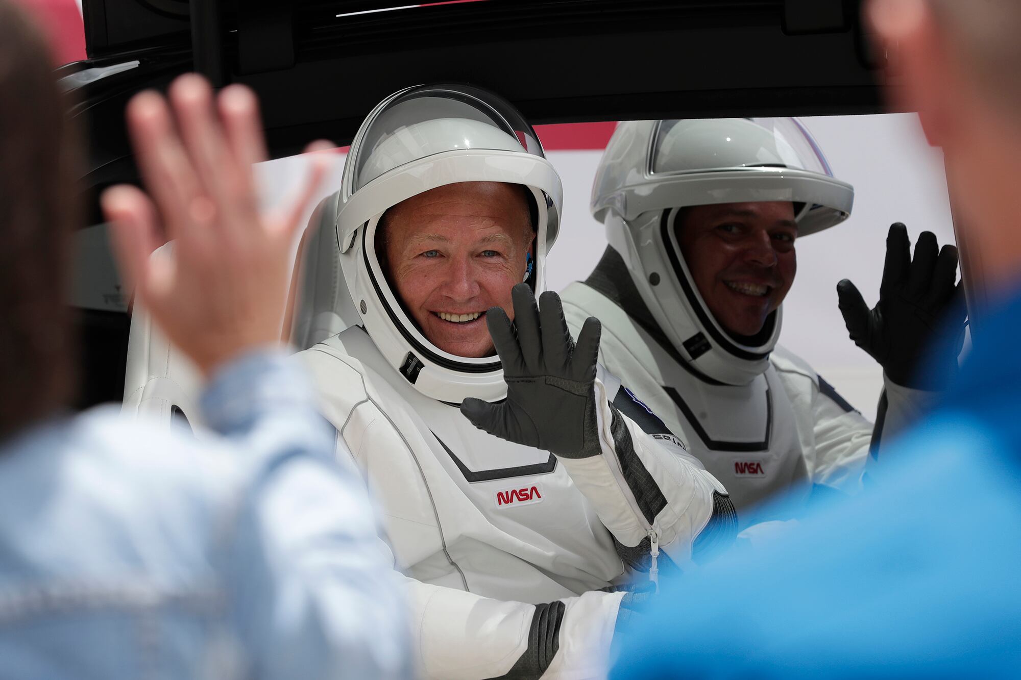 NASA astronauts Douglas Hurley, left, and Robert Behnken ride a Tesla SUV from the Neil A. Armstrong Operations and Checkout Building on their way to Pad 39-A, at the Kennedy Space Center in Cape Canaveral, Fla., Wednesday, May 27, 2020.