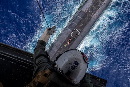 Staff Sgt. Ruben Arzate lowers a payload from an MV-22B Osprey to the Ohio-class ballistic-missile submarine USS Henry M. Jackson (SSBN 730) in the vicinity of the Hawaiian Islands on Oct. 21, 2020.