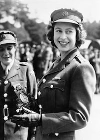 Britain's Princess Elizabeth, a Junior Commander in the Auxiliary Territorial Service, receives a clock presented to her by her old associates at the camp where she received her early training, during a ceremony at the No. 1 M.T. Training Center, in Camberley, England, Aug. 3, 1945.