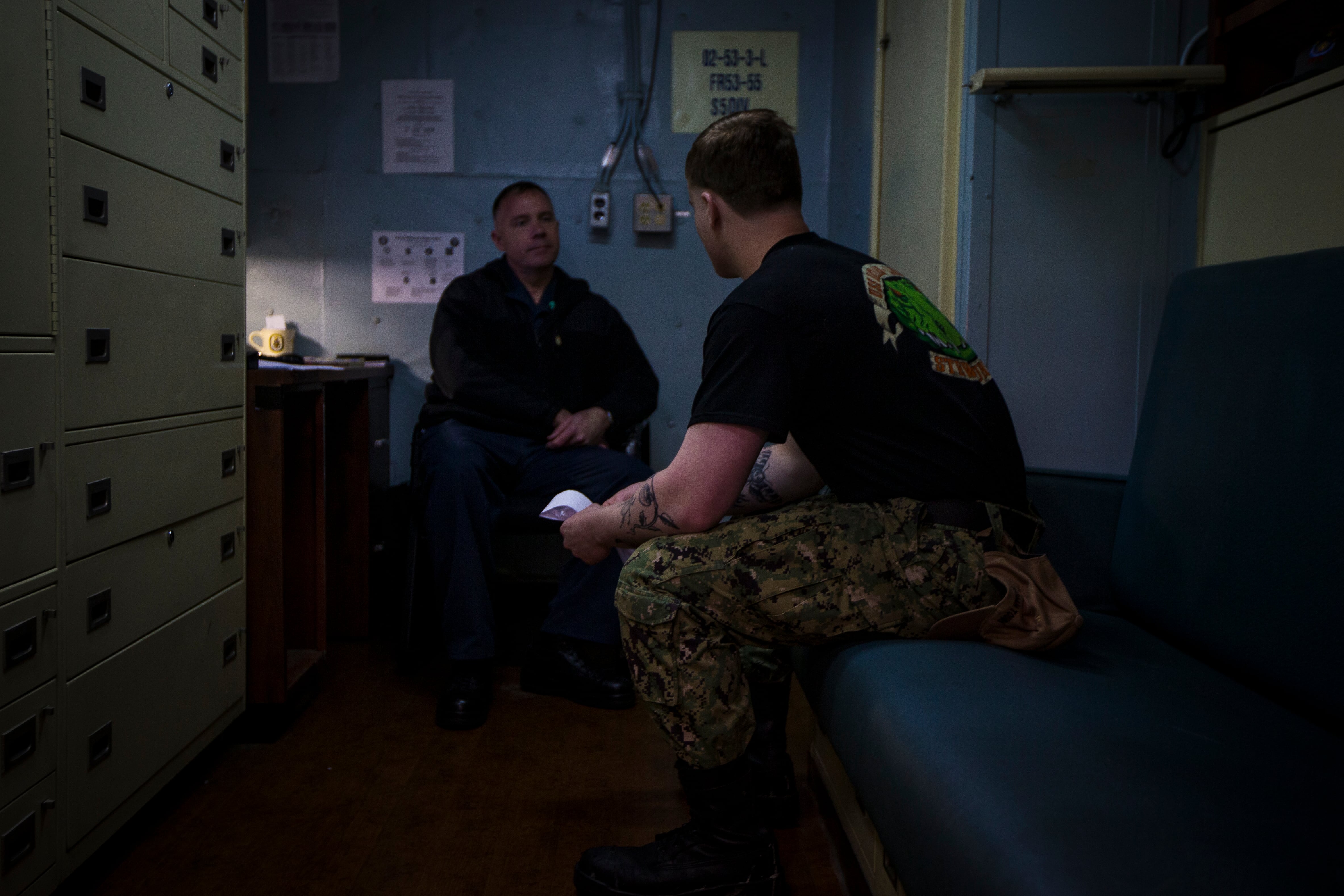 Navy Chaplain Lt. Cmdr. Ben Garrett counsels a sailor in his quarters on the USS Bataan on Monday, March 20, 2023 at Norfolk Naval Station in Norfolk, Va.