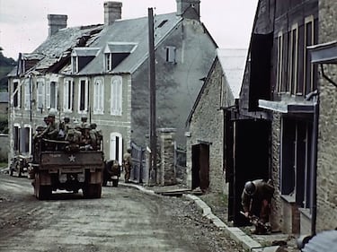 U.S. troops drive through a town during World War II in France