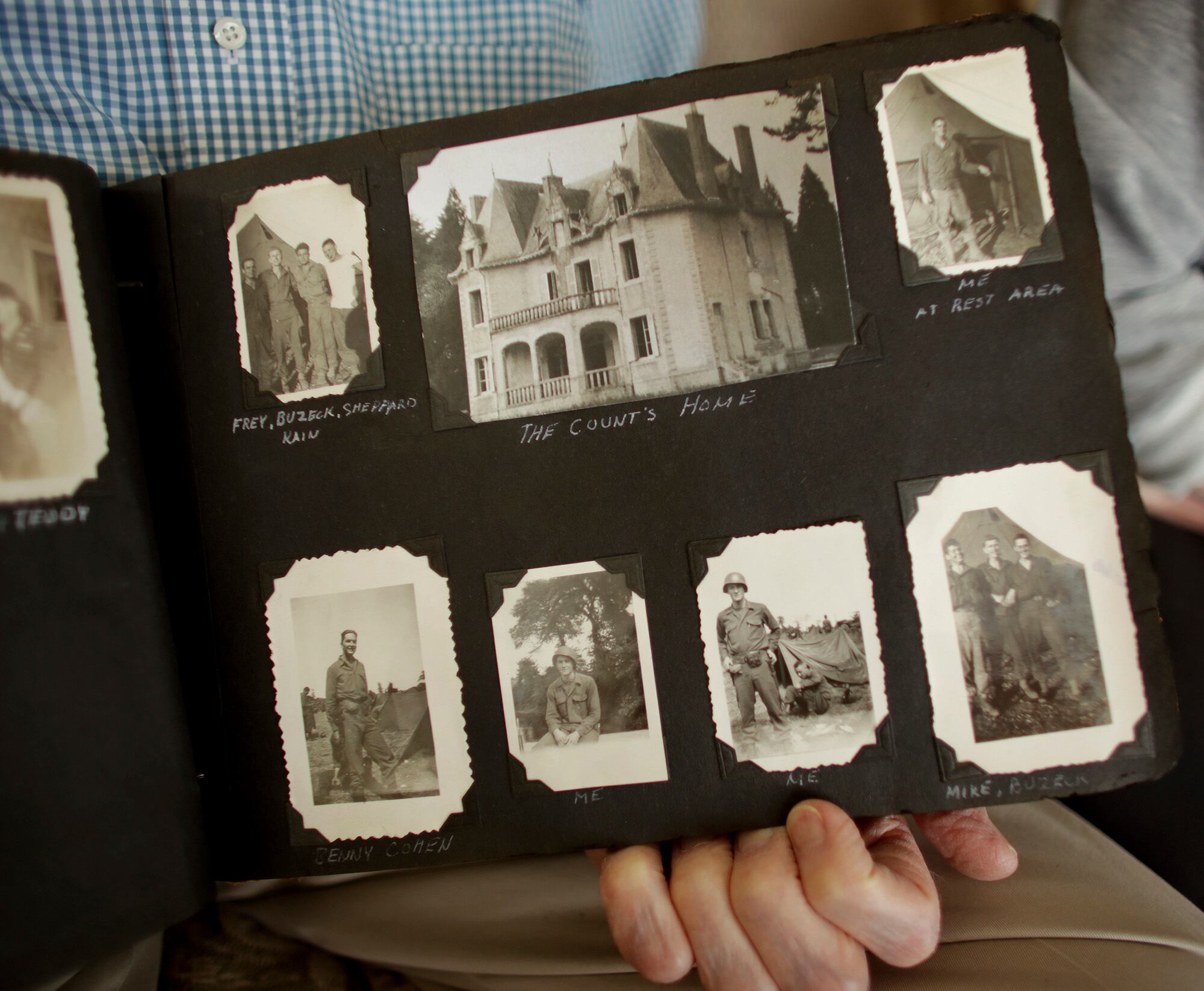 Veteran John Waller displays a photo album, Thursday, Sept. 24, 2020, in Virginia Beach, Va., showing a house in France where he took a painting.