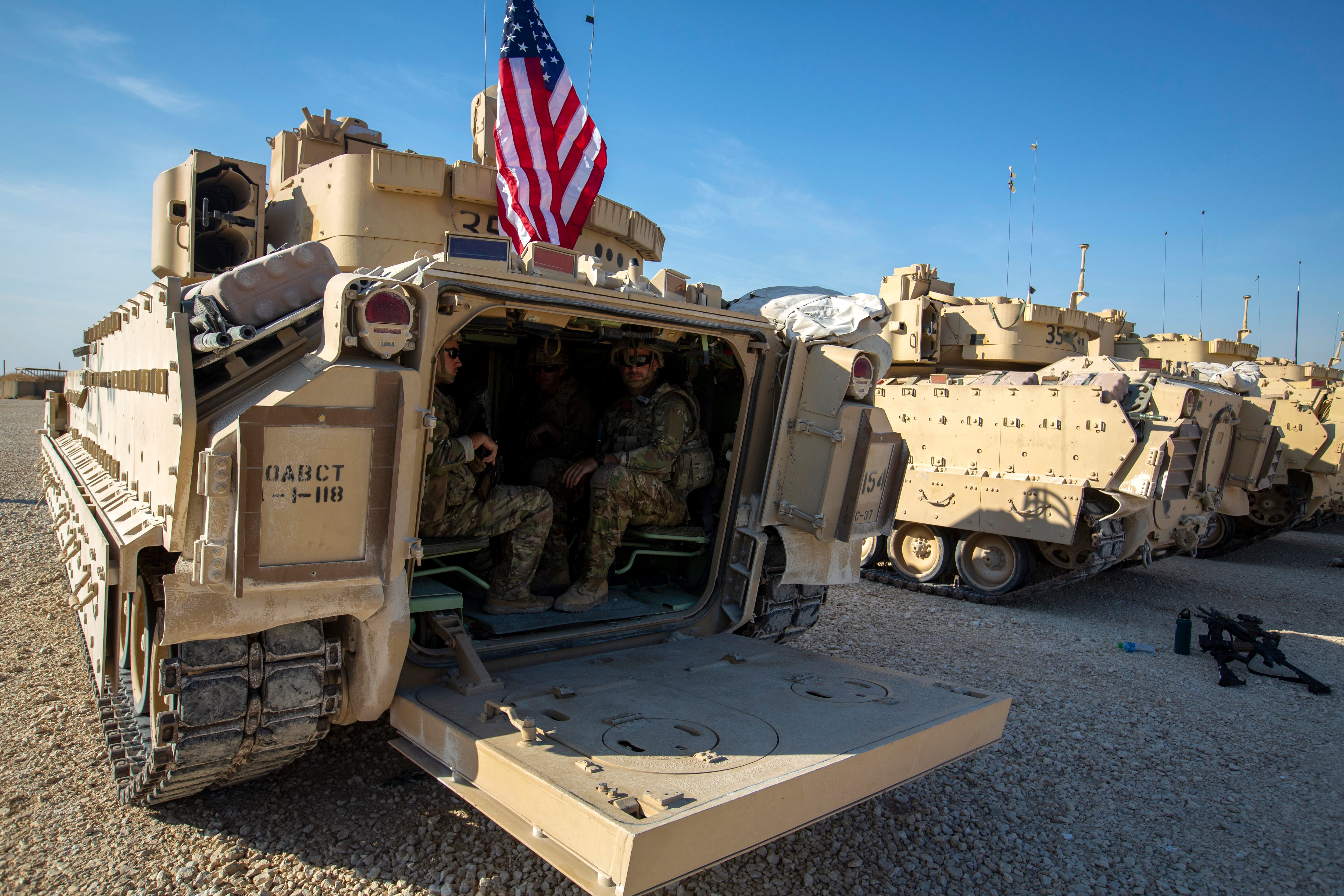 Crewmen sit inside Bradley fighting vehicles