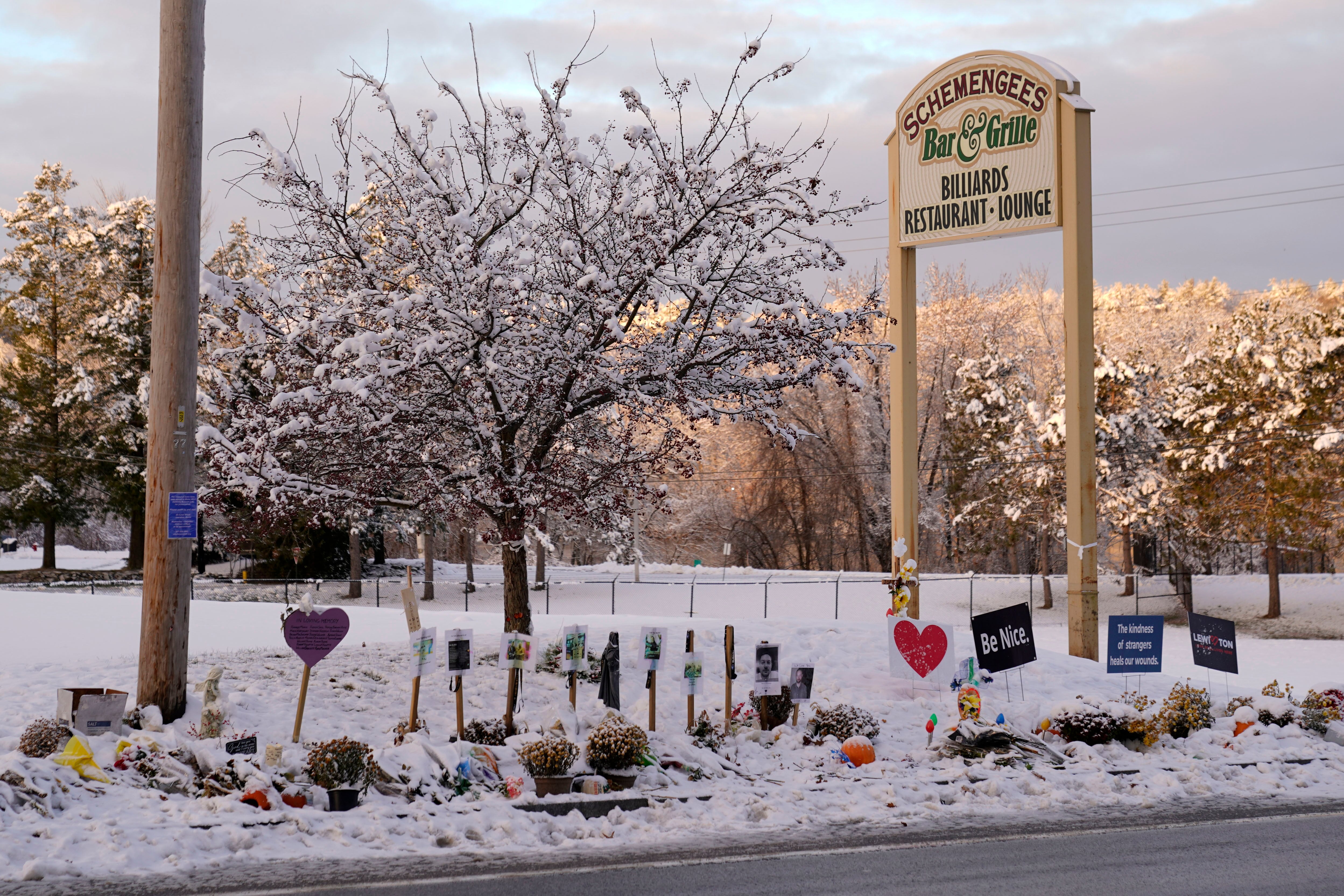 Snow accumulates outside a restaurant at a makeshift memorial for the victims of last month's mass shooting in Lewiston, Maine, Tuesday, Dec. 5, 2023.