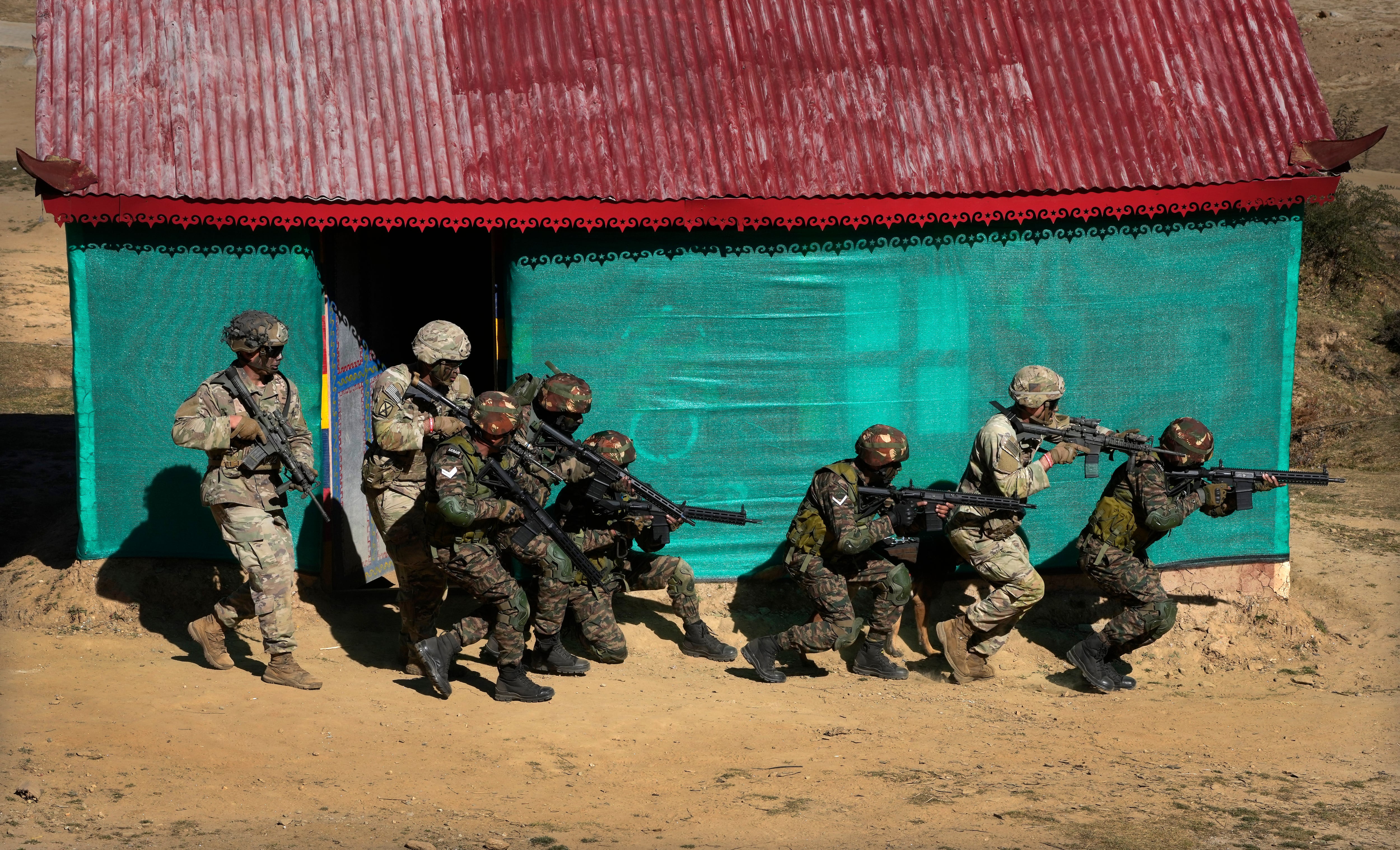 US Army soldiers of 2nd Brigade of the 11th Airborne Division and Indian army soldiers carry out a mock operation to flush out armed gunmen from a house during the Indo-US joint exercise or "Yudh Abhyas," in Auli, in the Indian state of Uttarakhand, Tuesday, Nov. 29, 2022.