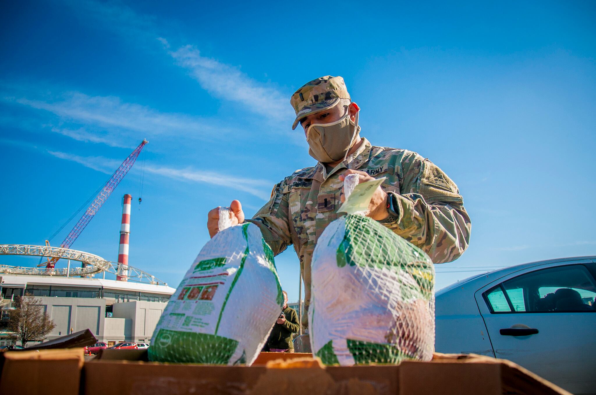 U.S. Army 1st Lt. Edwin Escobar, assigned to the Connecticut National Guard's 643rd Military Police Company, grabs a couple of turkeys for families during the Bridgeport Rescue Mission's annual Great Thanksgiving Project on Nov. 20, 2020, in Bridgeport, Conn