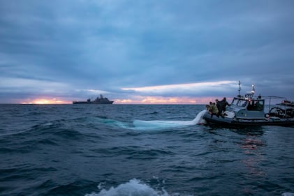 Sailors recover a high altitude surveillance balloon off the coast of Myrtle Beach, South Carolina, while the dock landing ship USS Carter Hall transits nearby, Feb. 5, 2023.