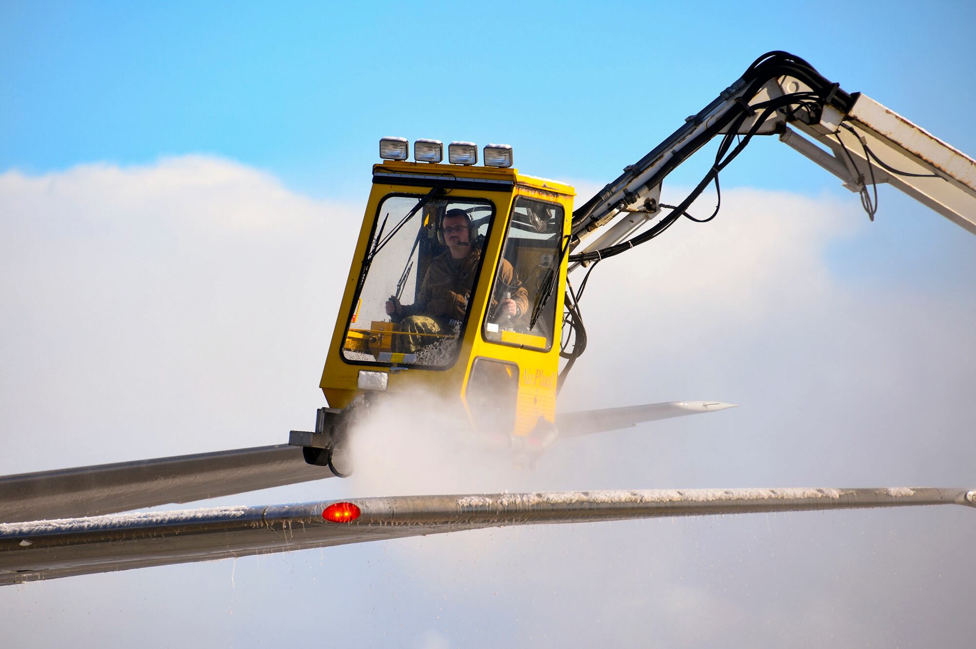 Aviation Machinist’s Mate 1st Class Andrew Sutton operates a de-icing truck to remove snow and ice from the wing of a P-8A Poseidon on Nov. 10, 2020, at Misawa Air Base.