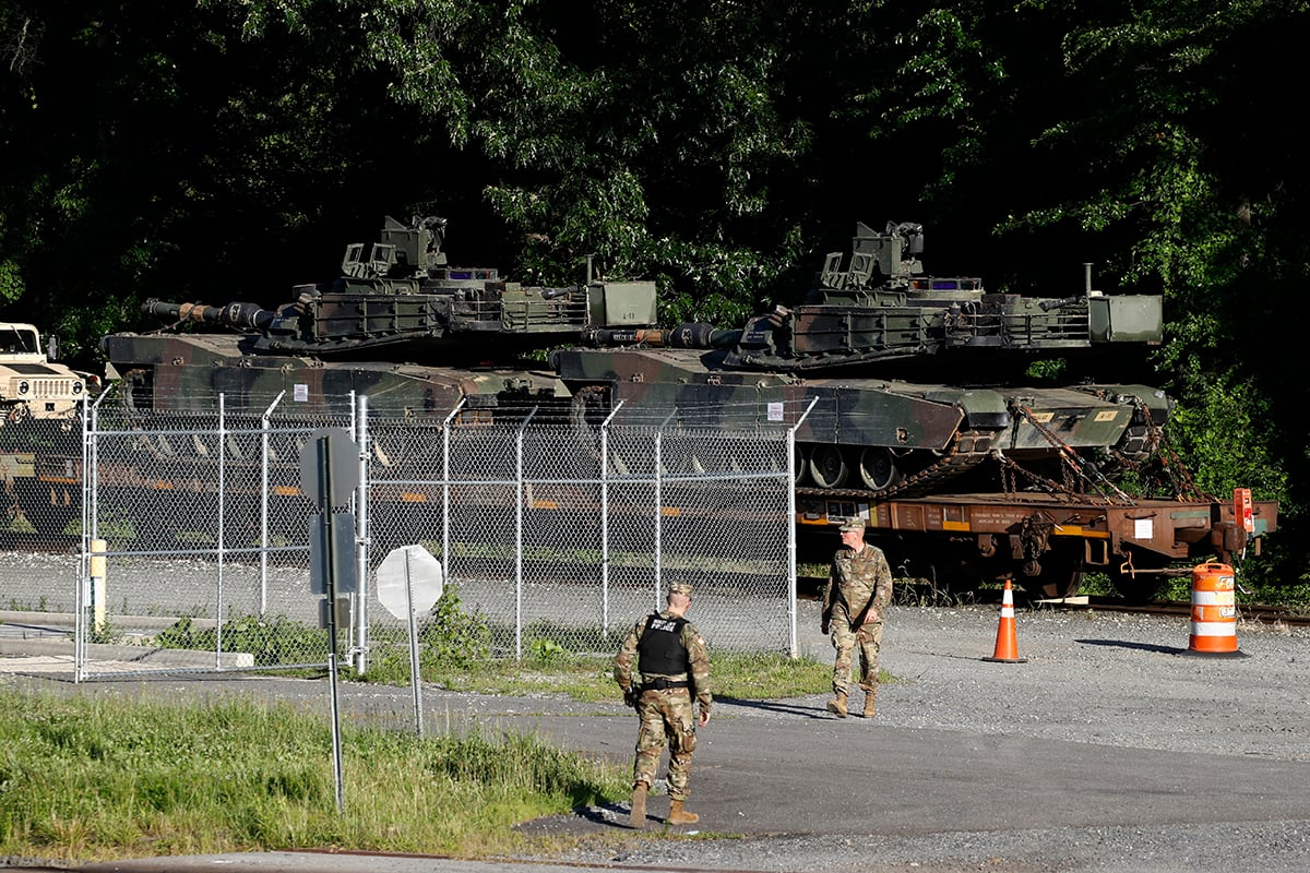 Military police walk near Abrams tanks on a flat car in a rail yard, Monday, July 1, 2019, in Washington, ahead of a Fourth of July celebration that President Donald Trump says will include military hardware.