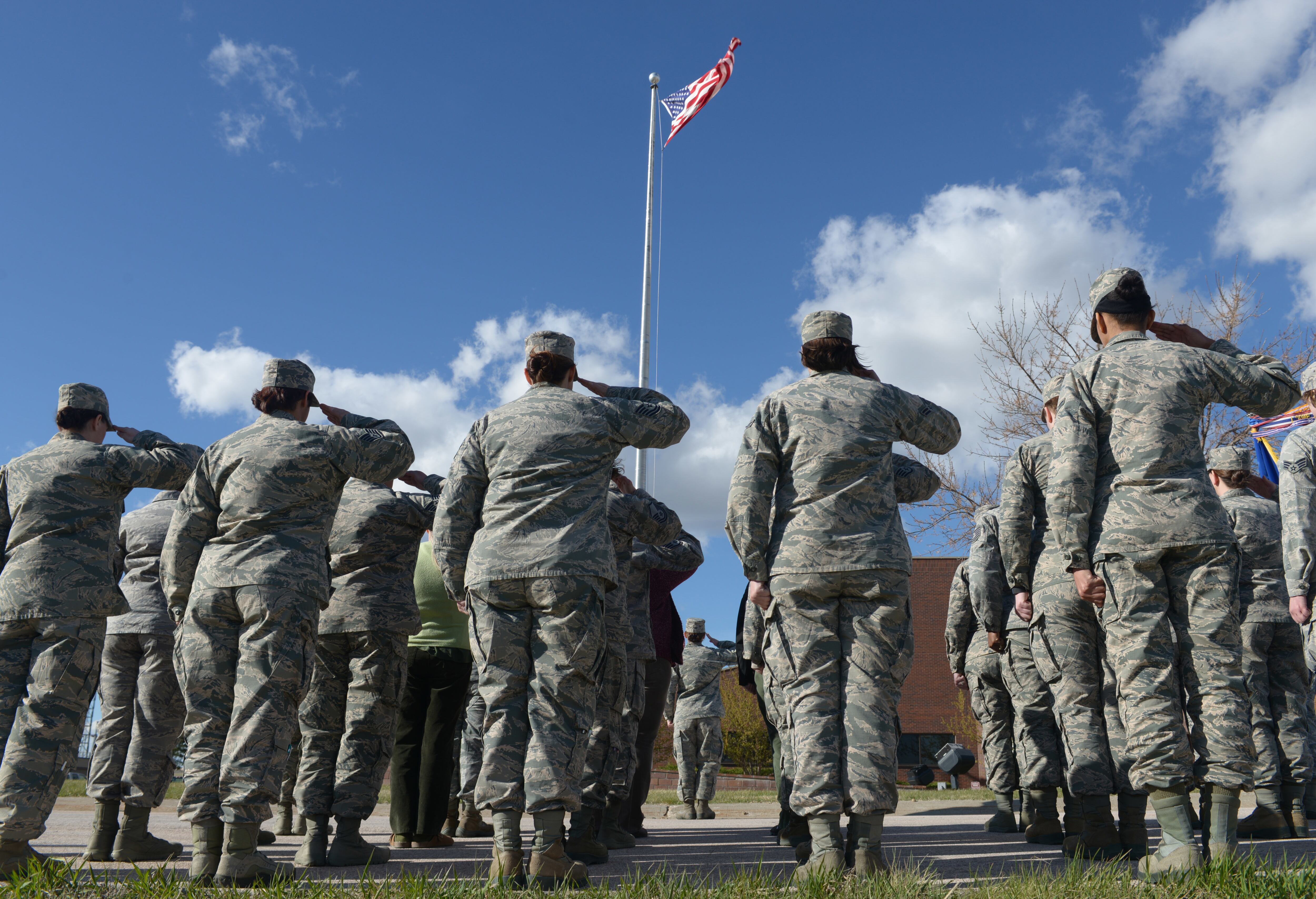 Airmen salute the American flag as it is lowered during the women’s retreat ceremony at Ellsworth Air Force Base, S.D., April 7, 2016.