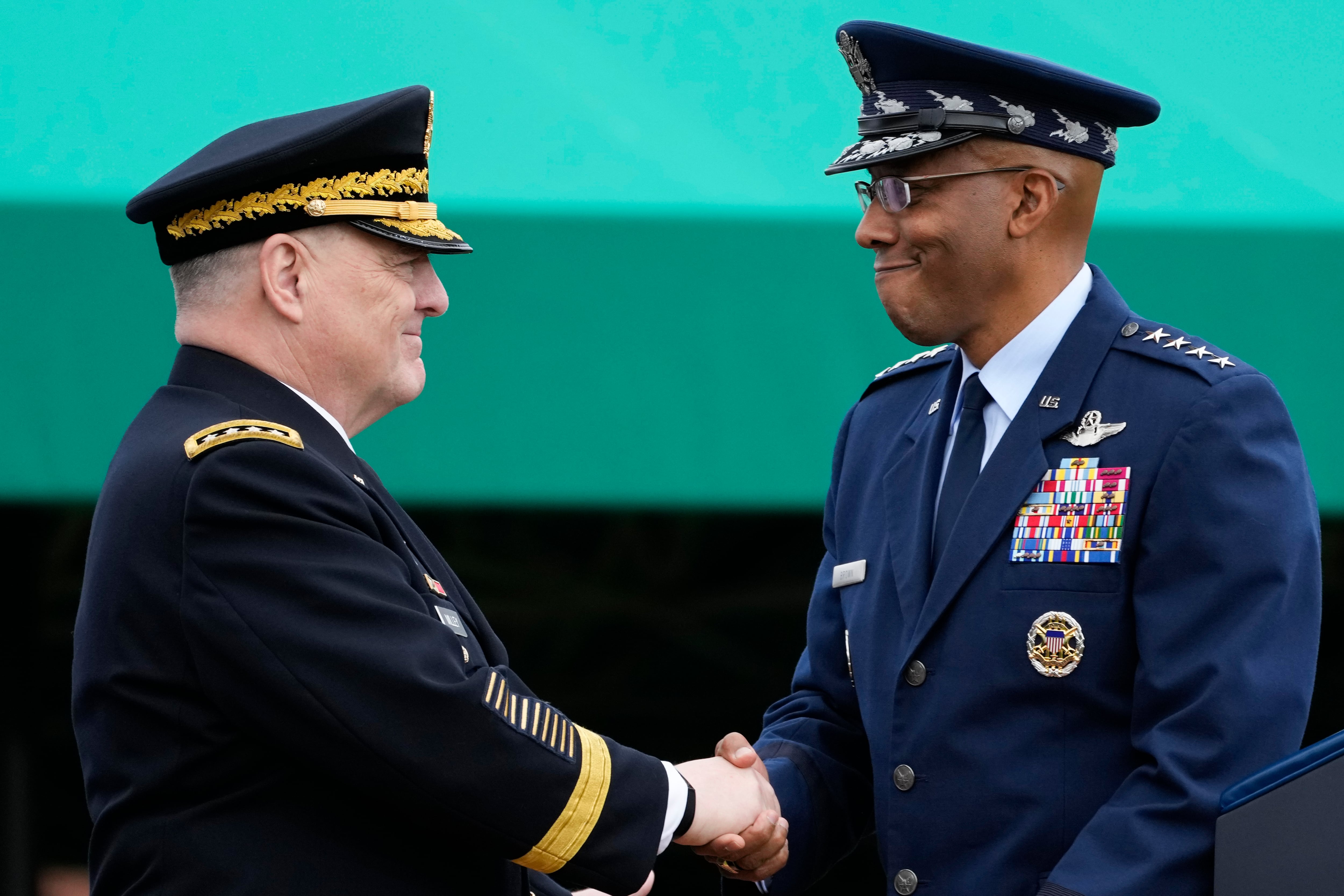 Retiring Chairman of the Joint Chiefs of Staff Gen. Mark Milley, left, shakes hands with Gen. CQ Brown, Jr., the incoming chairman, right, during the Armed Forces Farewell Tribute in honor of Milley at Joint Base Myer-Henderson Hall, Friday, Sept. 29, 2023, in Fort Meyer, Va.