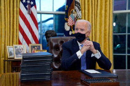 President Joe Biden waits to sign his first executive order in the Oval Office of the White House on Wednesday, Jan. 20, 2021, in Washington.