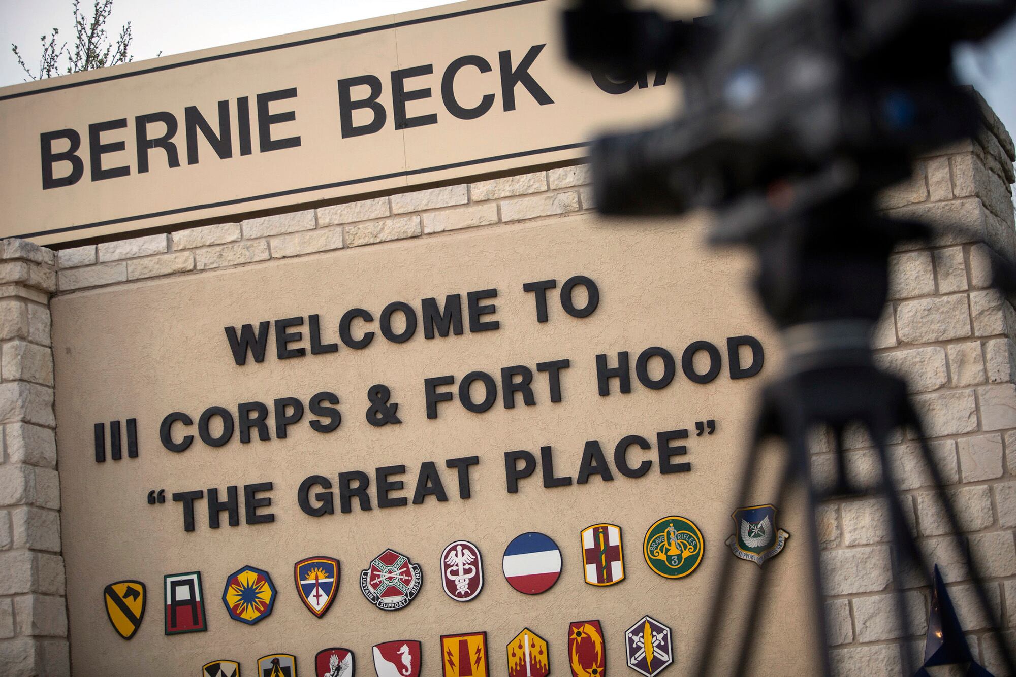 In this April 2, 2014, file photo, members of the media wait outside of the Bernie Beck Gate, an entrance to the Fort Hood military base in Fort Hood, Texas