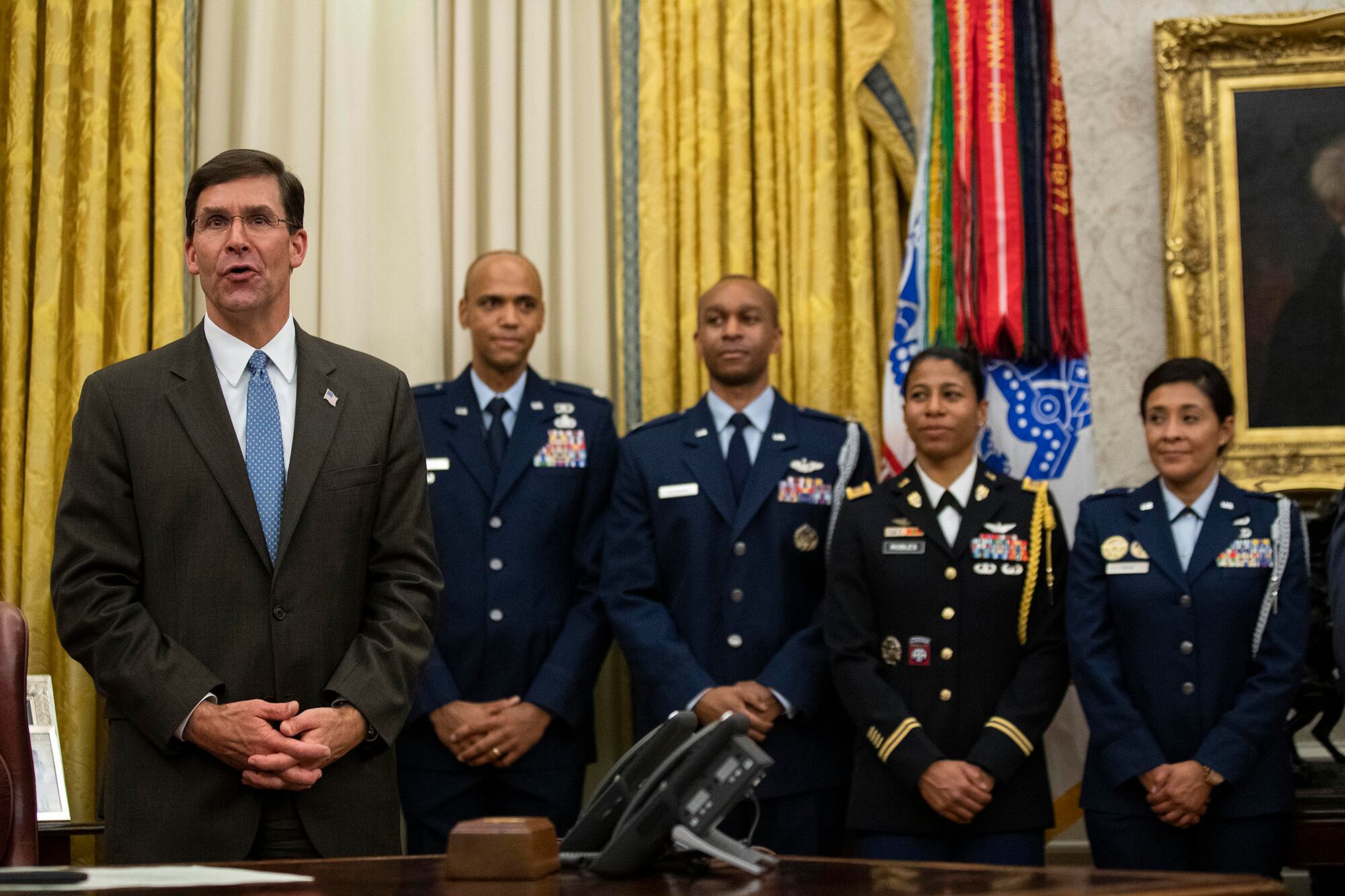 Secretary of Defense Mark Esper, left, speaks after a ceremony to swear in Gen. Charles Q. Brown Jr. as chief of staff of the Air Force in the Oval Office of the White House, Tuesday, Aug. 4, 2020, in Washington.