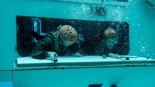 Assault Amphibian School students take a ride in the Submerged Vehicle Egress Trainer