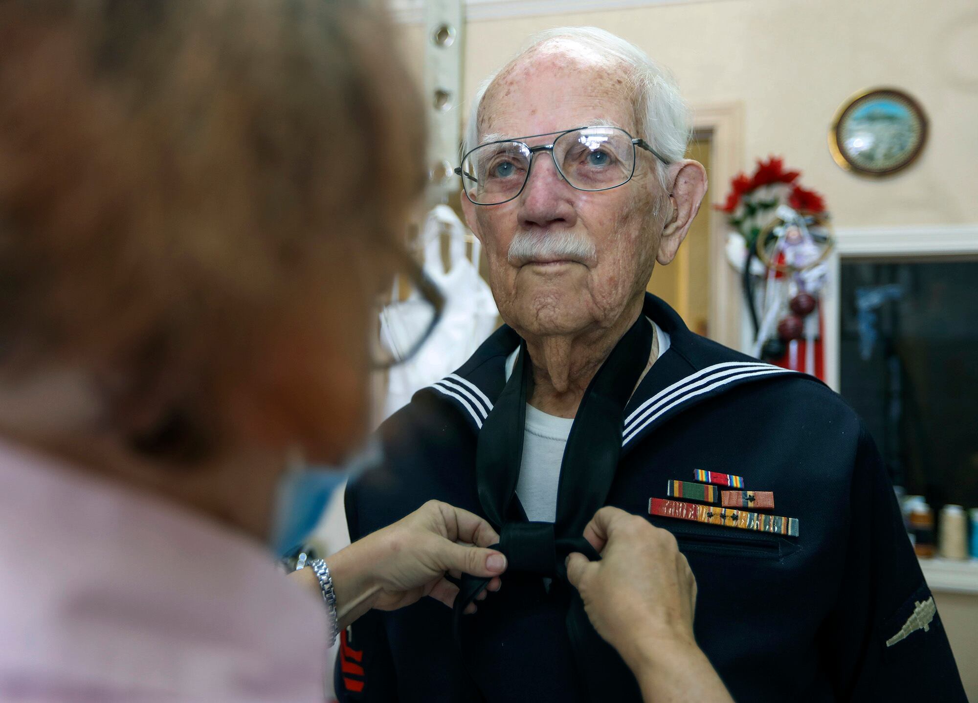 Joseph Hall, 96, of Dunedin, right, holds still as seamstress Susan Williams, 57, of Tarpon Springs, ties a knot into a tie Feb. 3, 2021, in Dunedin, Fla.