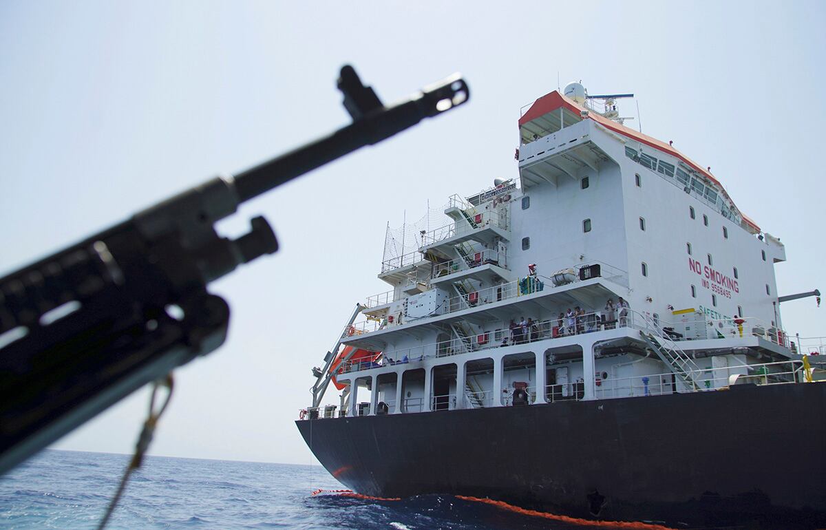 Sailors stand on deck above a hole the U.S. Navy says was made by a limpet mine on the damaged Panama-flagged, Japanese owned oil tanker Kokuka Courageous, anchored off Fujairah, United Arab Emirates