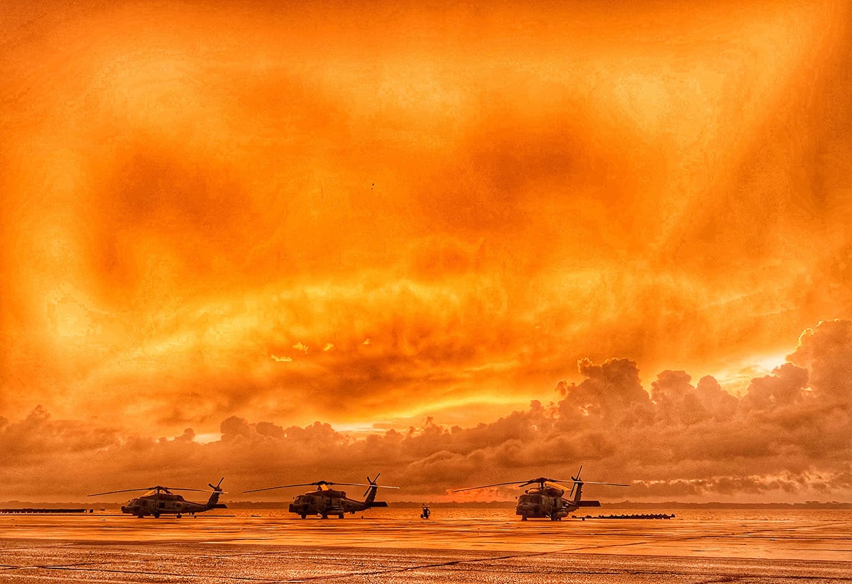 Three MH-60R Seahawk helicopters line the seawall at Naval Air Station Jacksonville on June 13, 2019, as the sun rises over the St. Johns River.