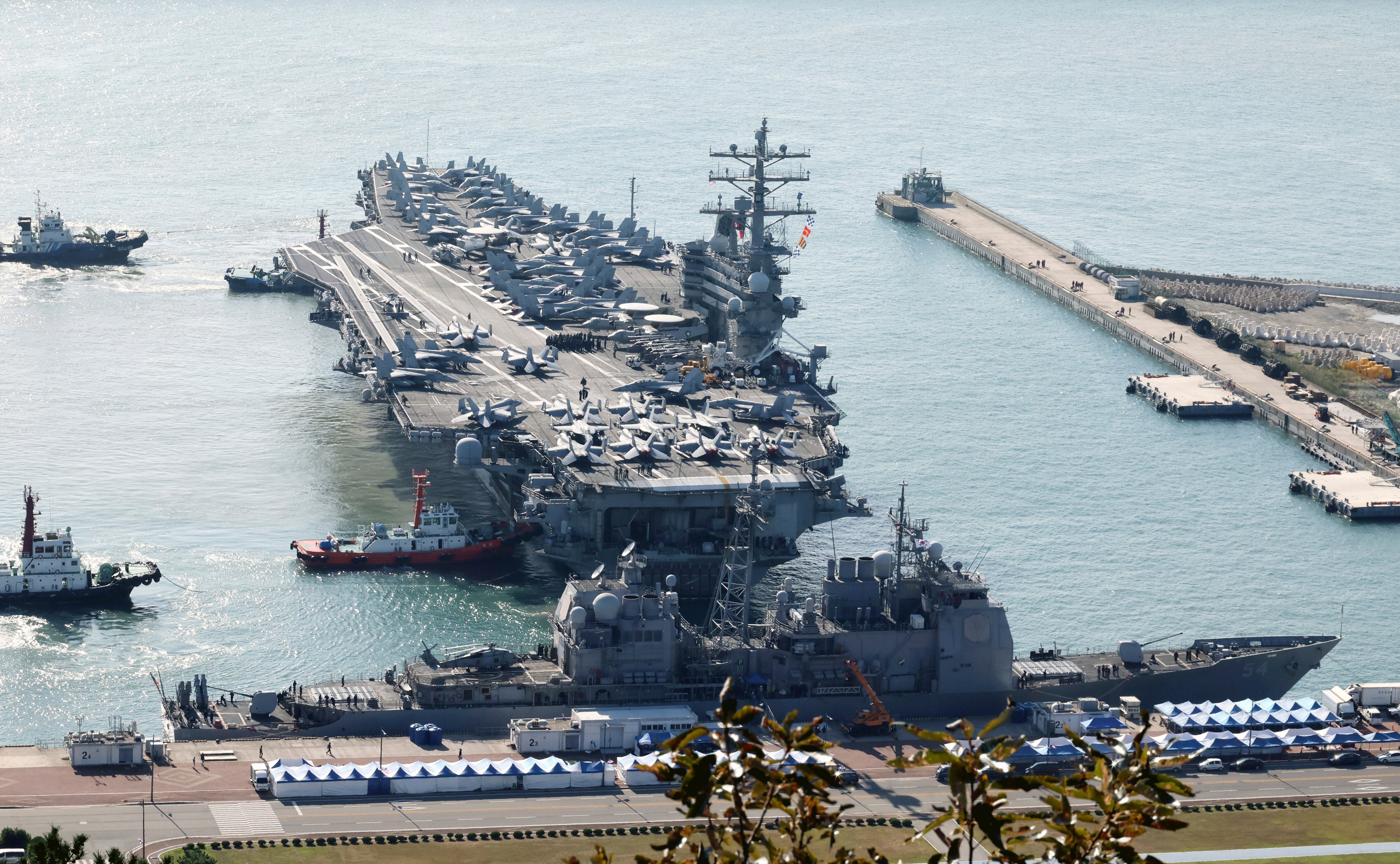 U.S. nuclear-powered aircraft carrier Ronald Reagan is escorted as it arrives in Busan, South Korea, Thursday, Oct. 12, 2023.