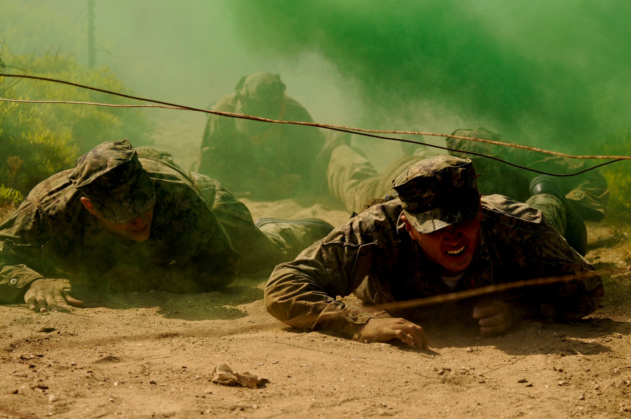 Special Warfare combatant-craft crewman candidates low-crawl under an obstacle during The Tour at Naval Special Warfare Center in Coronado, Calif., June 1, 2020.