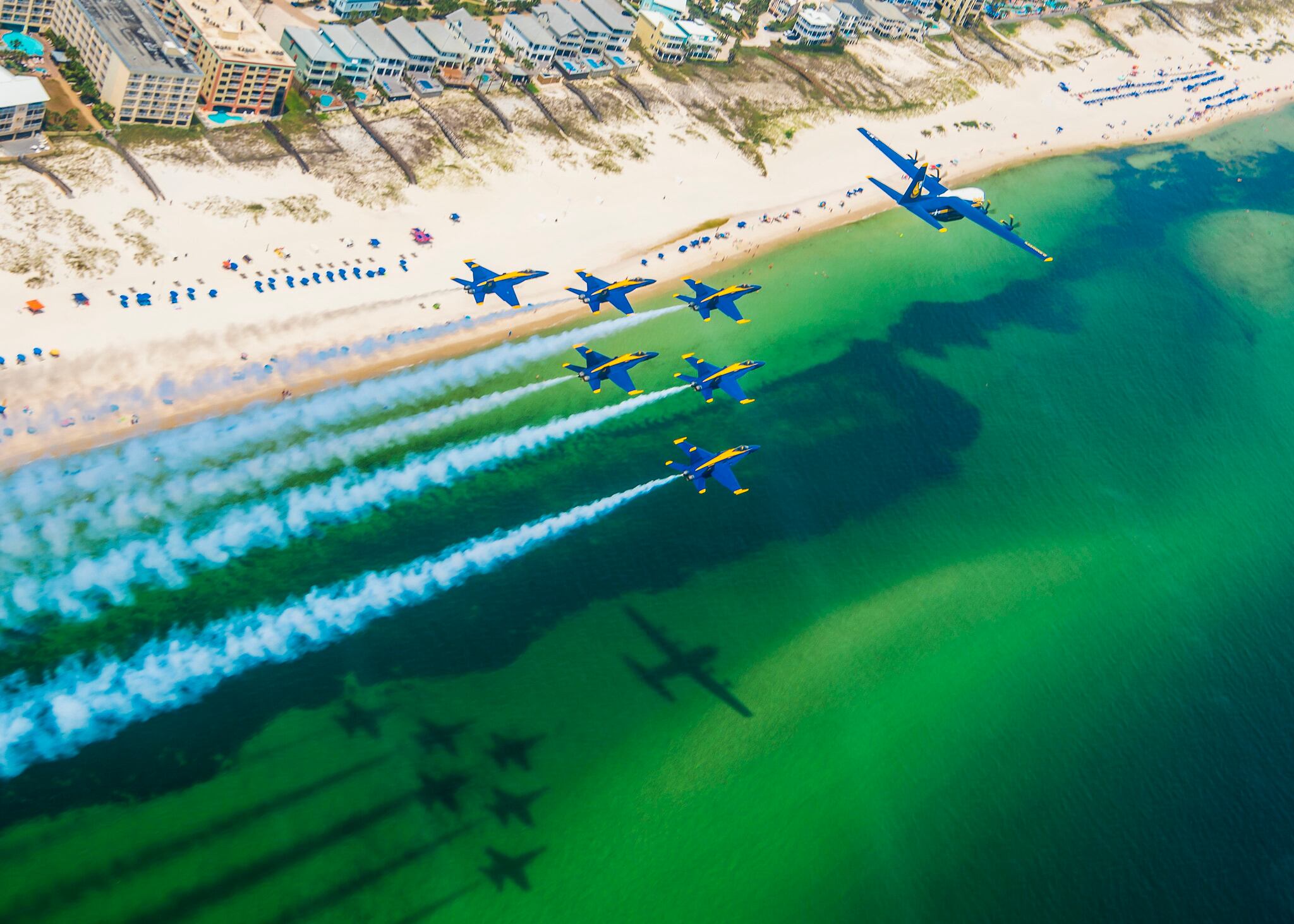 The U.S. Navy Flight Demonstration Squadron, the Blue Angels, C-130 pilots and crew arrive at Naval Air Station Pensacola with the team’s new C-130J Super Hercules, alongside the Blue Angel delta formation on Aug. 17, 2020.