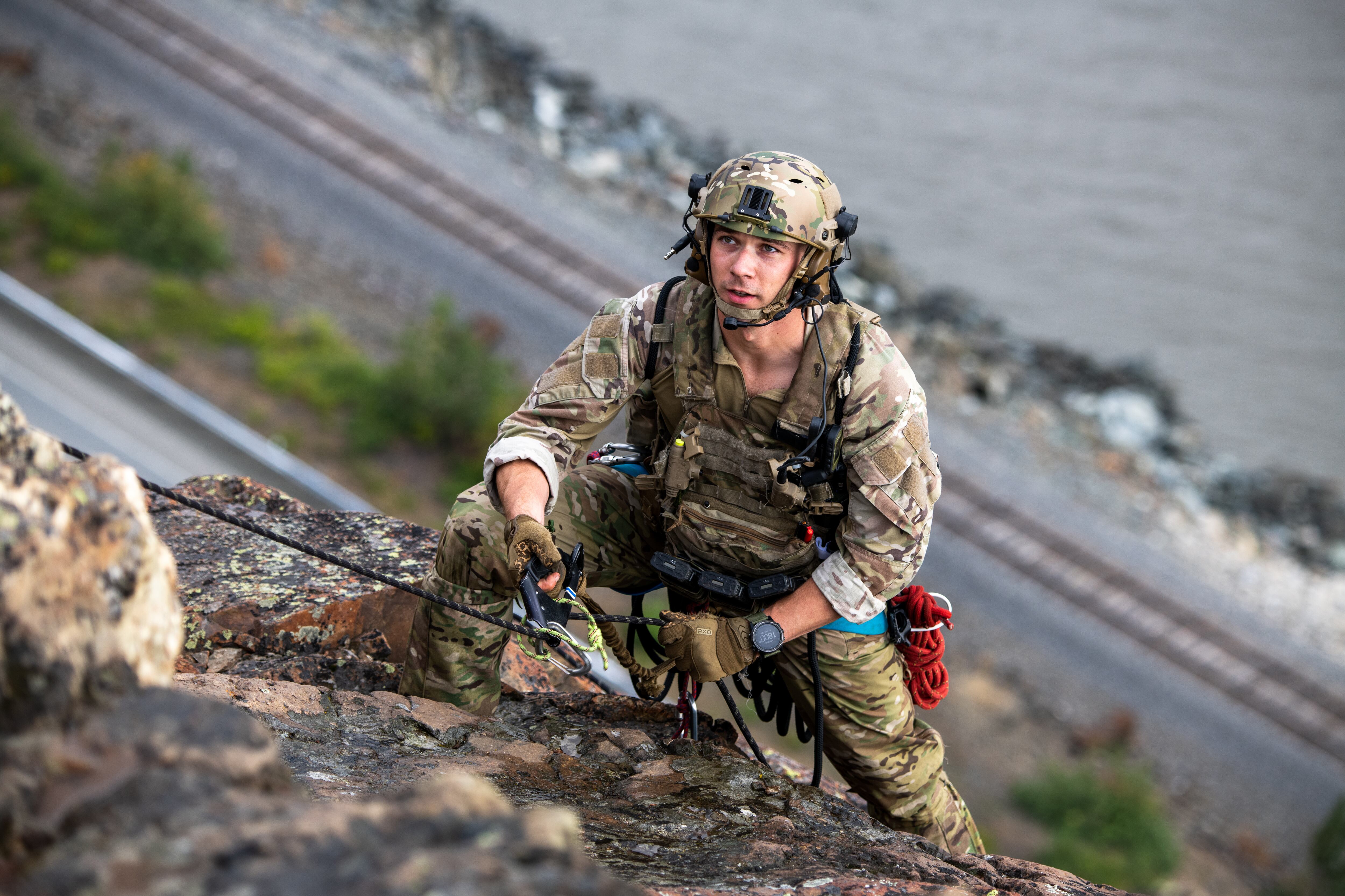 Staff Sgt. Trenten Collins, a tactical air control party specialist assigned to Detachment 1, 3rd Air Support Operations Squadron, approaches the cliff summit during mountaineering training at Sunshine Ridge, Alaska, July 22, 2022. (Senior Airman Patrick Sullivan/Air Force)