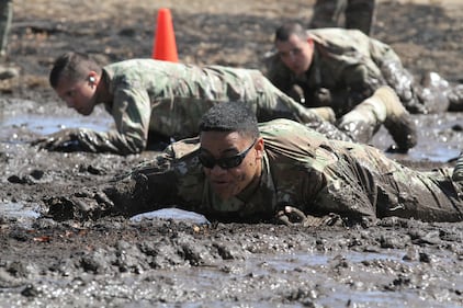 U.S. Army Sgt. Miguel Leyua of the California National Guard’s 330th Military Police Company, 143rd Military Police Battalion, 49th Military Police Brigade, one of the cadres of the 49th’s 2020 Best Warrior Competition, low crawls through a mud pit during the competition, Aug. 8-12, 2020 at Camp Roberts, Calif.