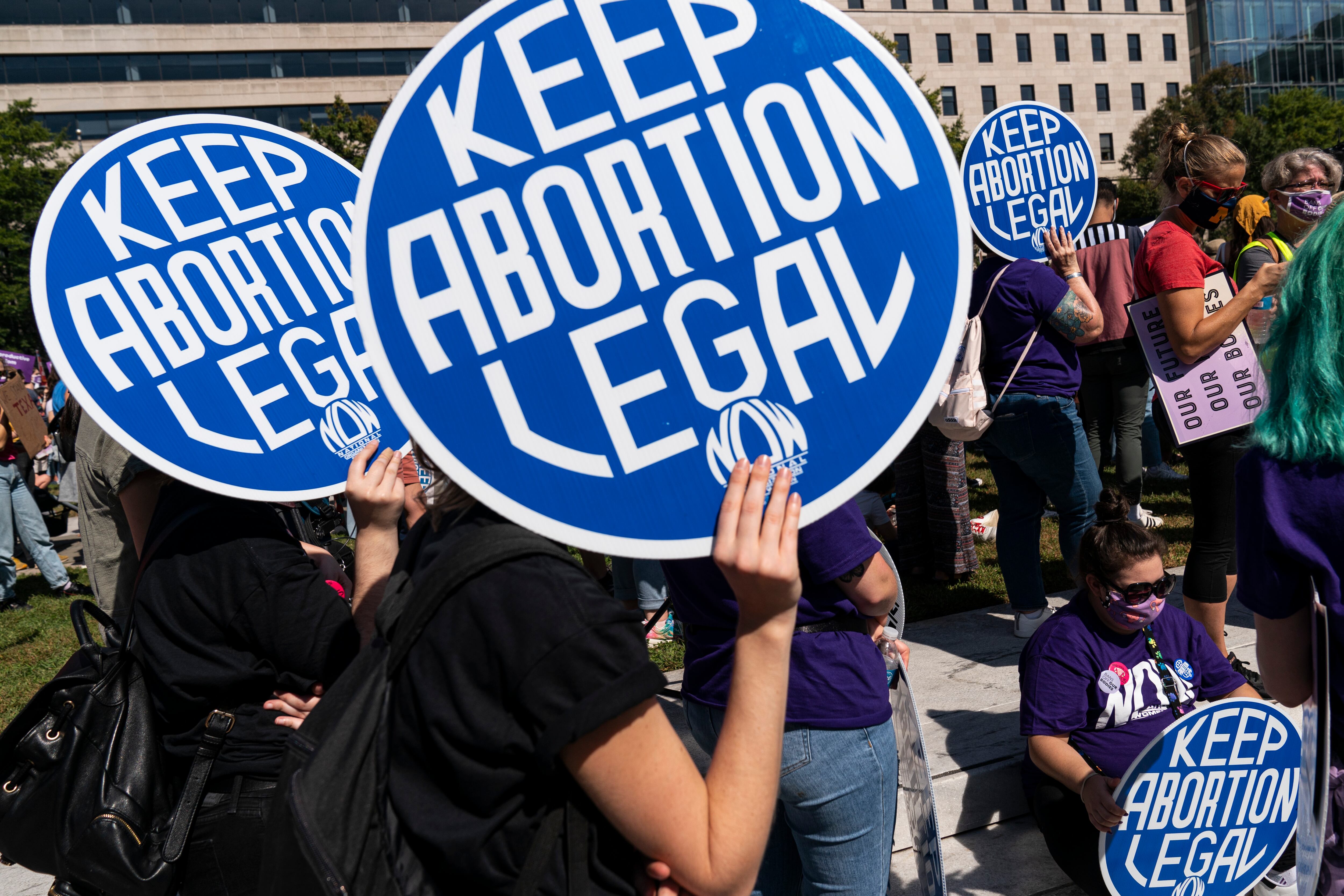 Women rights activists hold up signs as they gather at Freedom Plaza for a pre-march rally of the annual Womens March October 2, 2021 in Washington, DC.